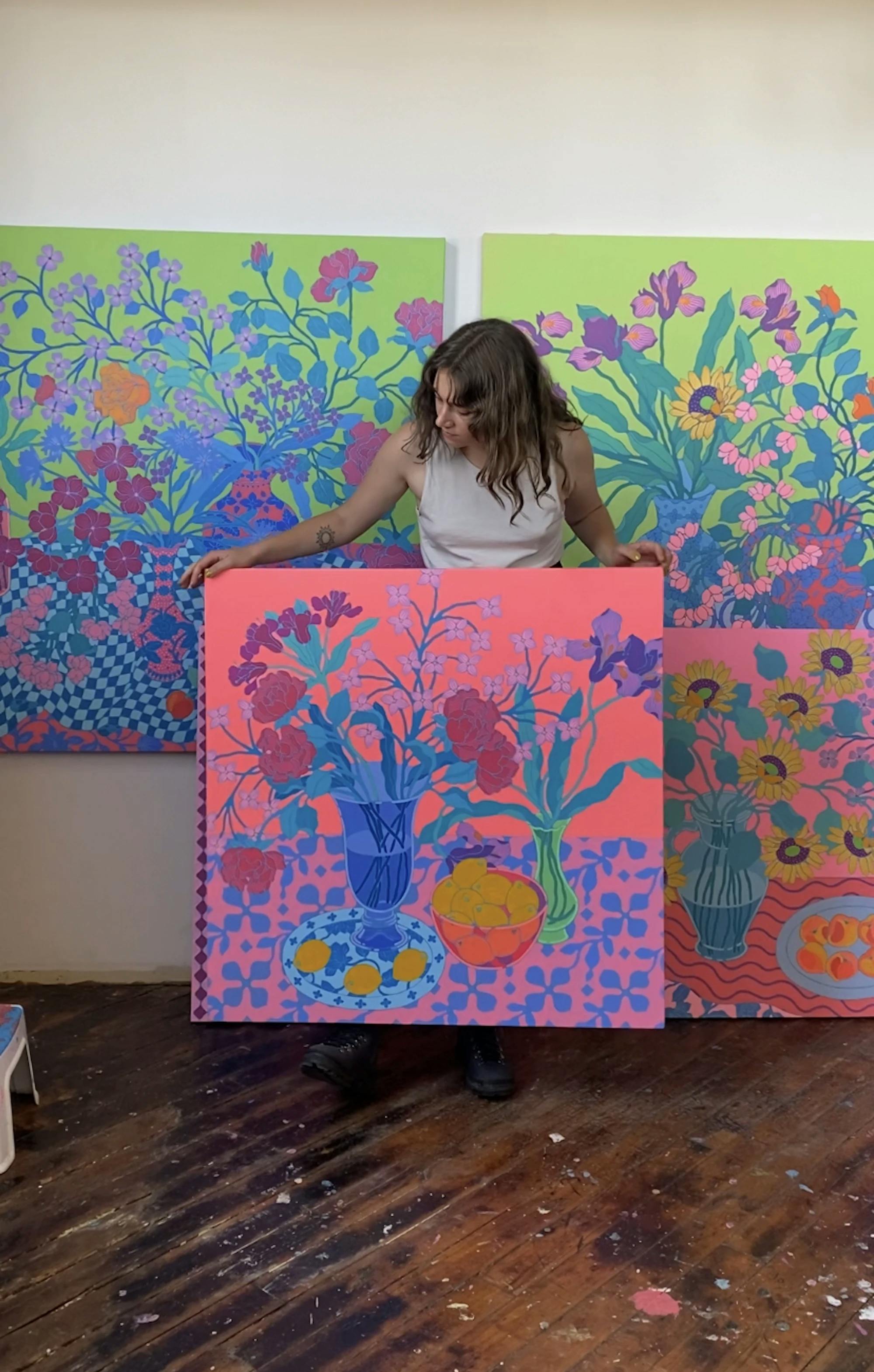 Artist Sarah Ingraham holding a large floral painting. 