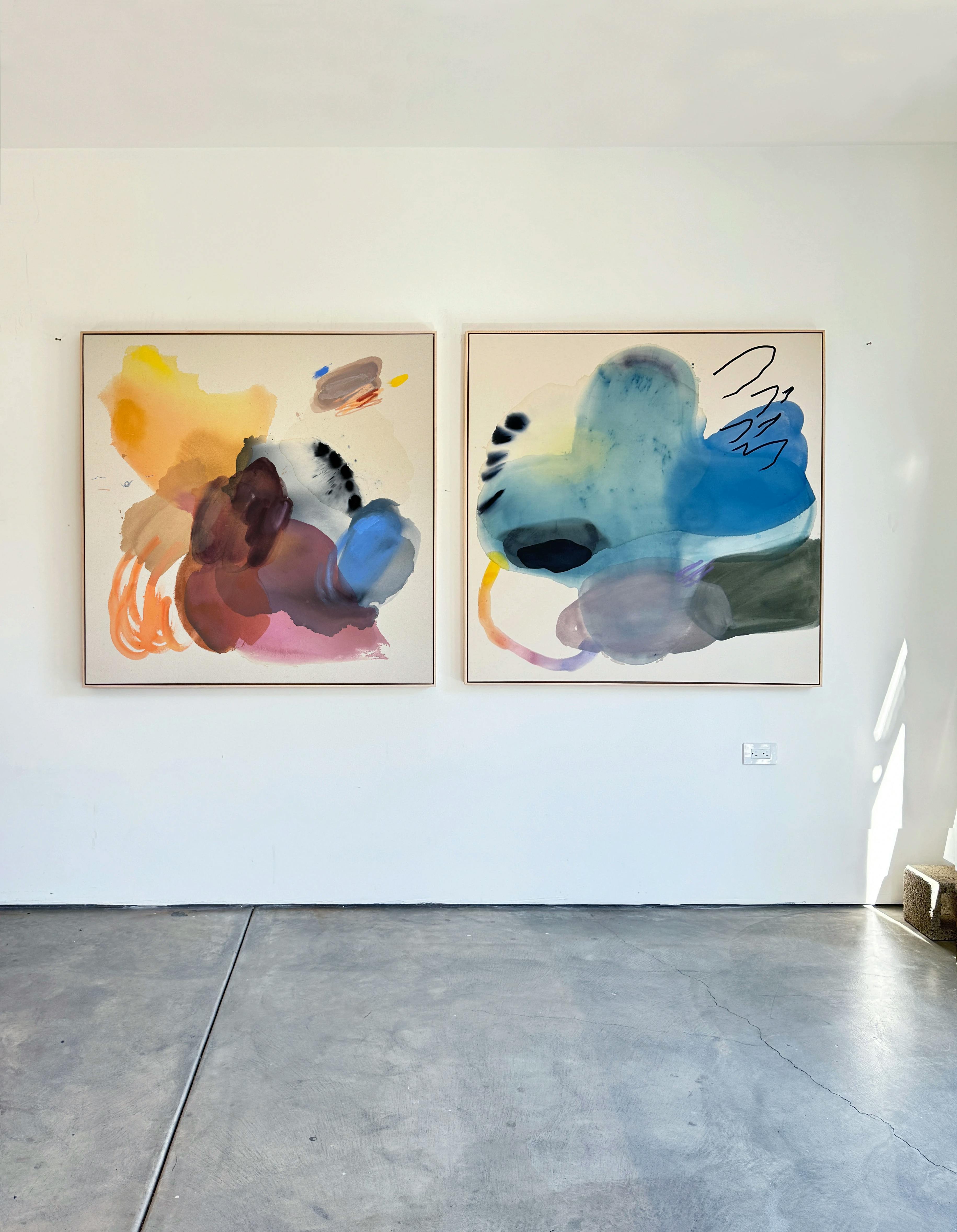 Two colorful and gestural brushwork paintings on canvas installed on a white wall in artist Karina Bania's studio.