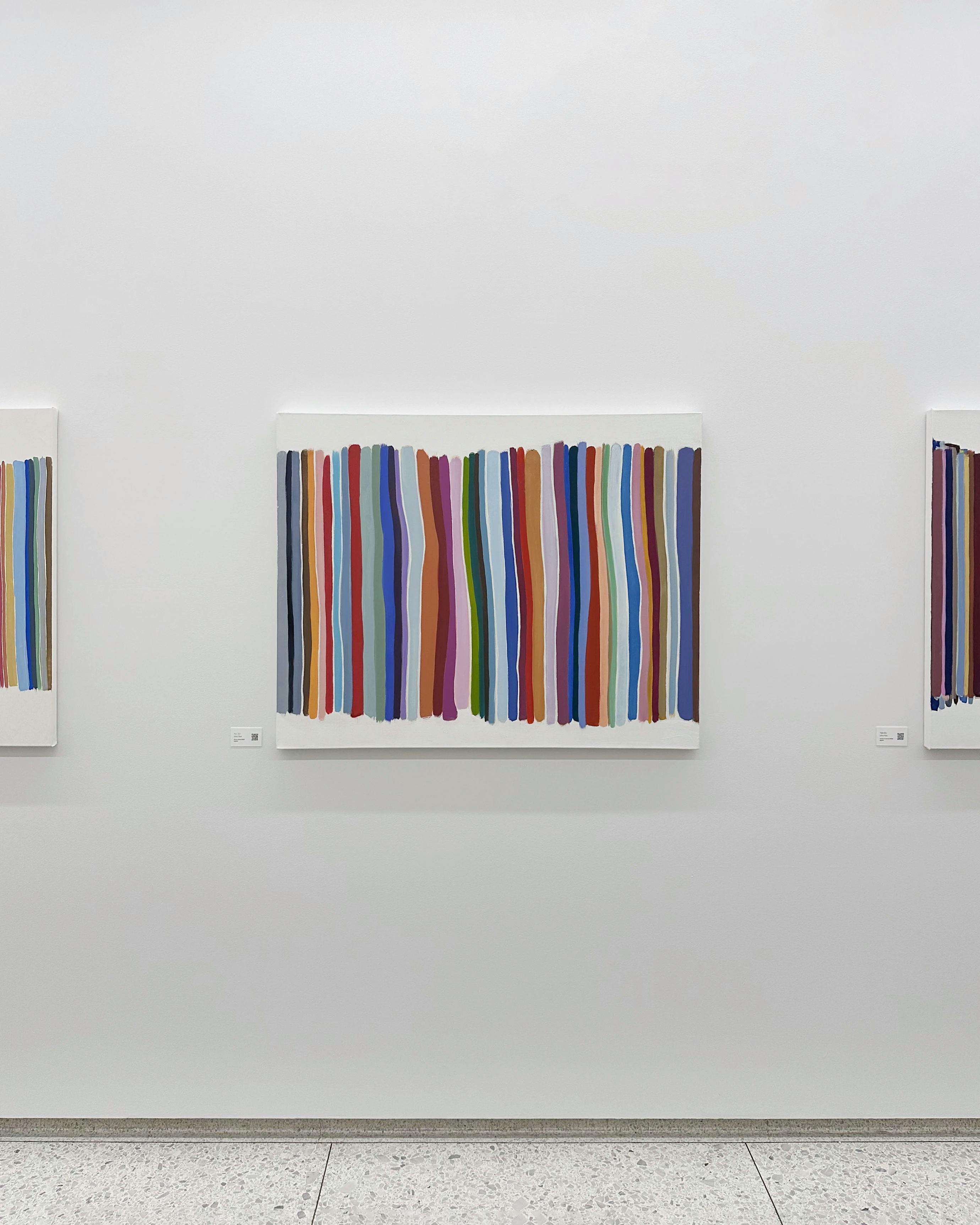 A row of paintings by John Platt in exhibition Stories in Color at Alchemy Properties.