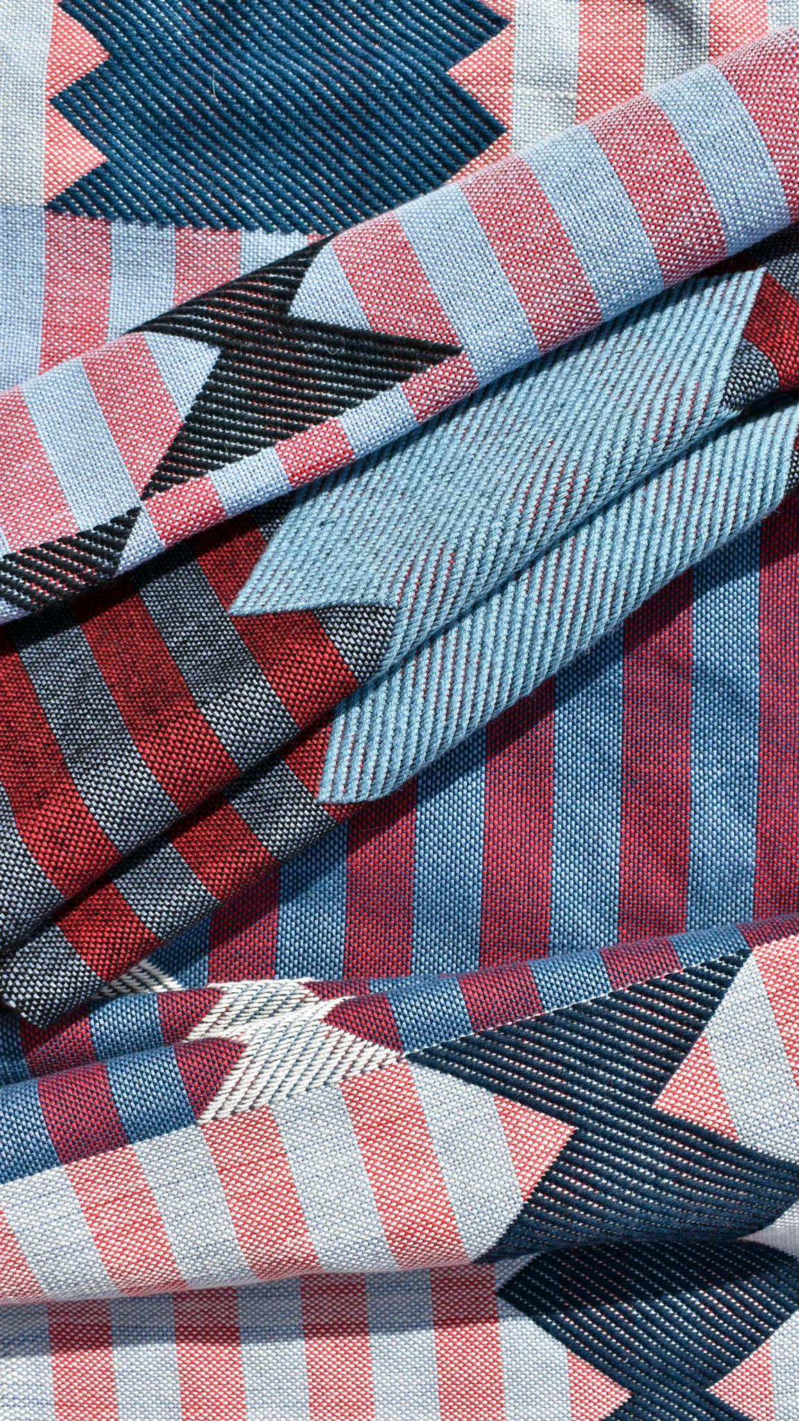 A close-up of a woven blue and pink striped fabric with folds in it by artist Sarah Sullivan Sherrod.