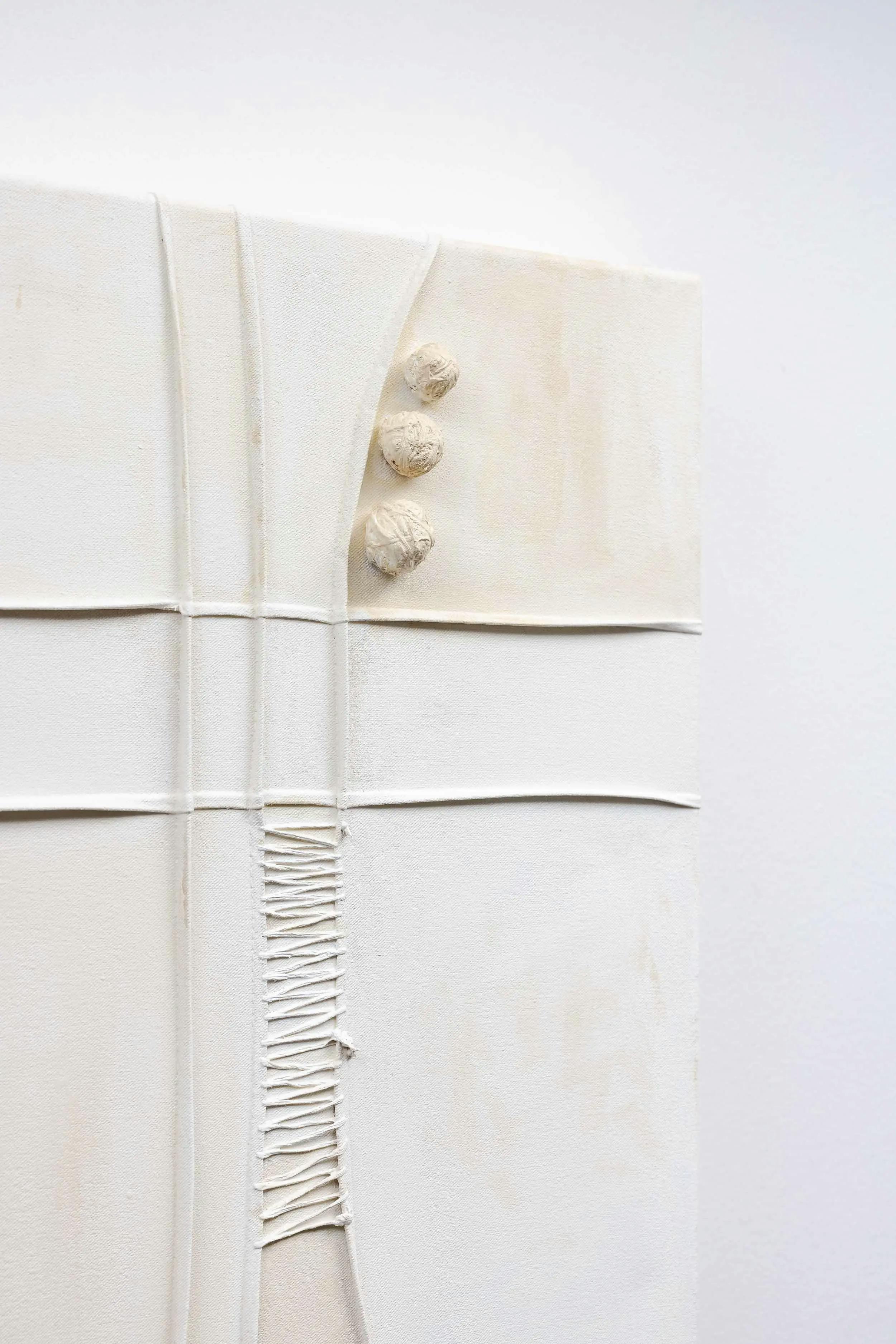 A close up of a hand-stitched, minimalist white painting by artist Nicole Anastas.