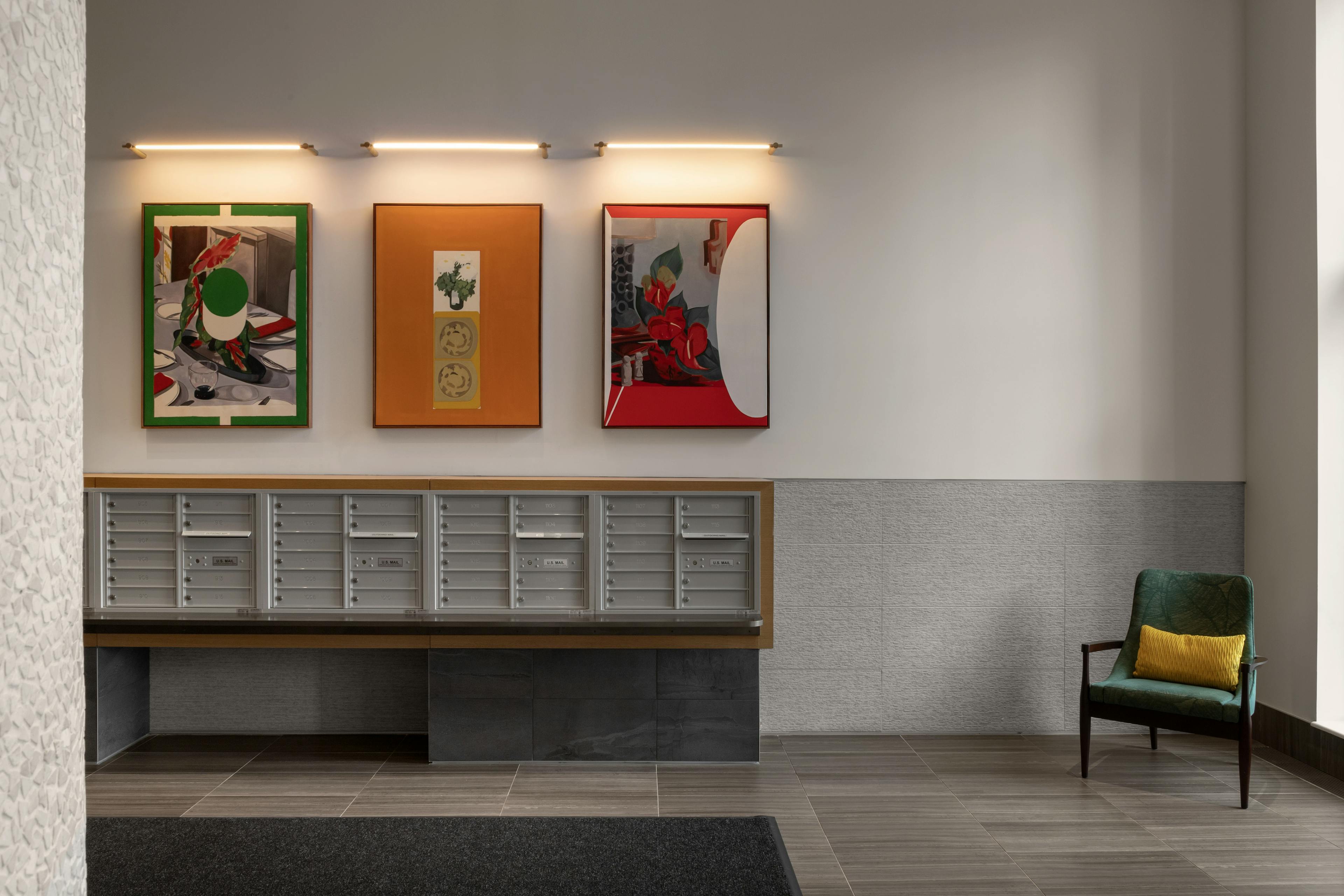Three paintings by artist Bryce Anderson installed above mailboxes in a mailroom at Gotham Point. 