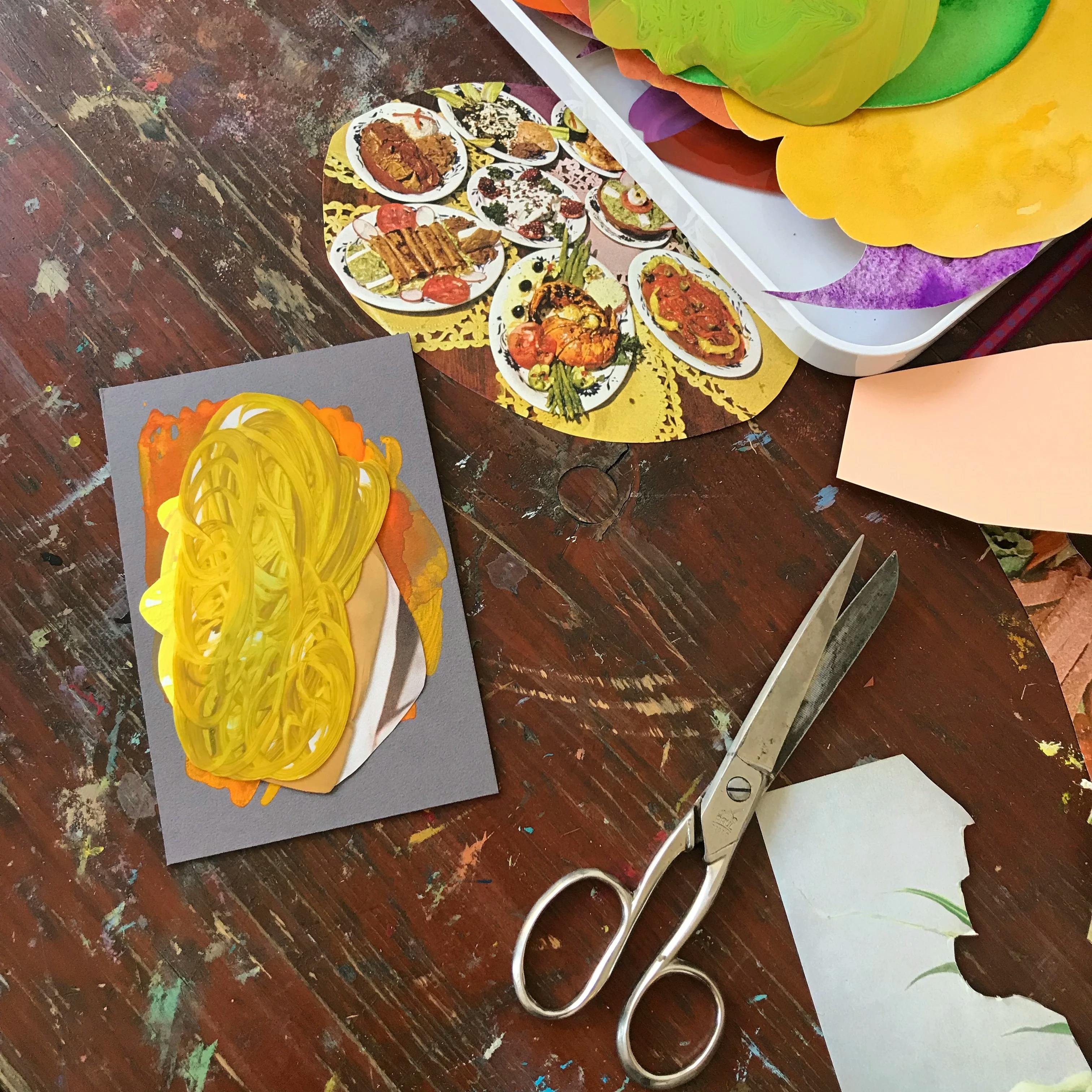 An in-progress yellow work by artist Xochi Solis next to a pile of source material in her studio.