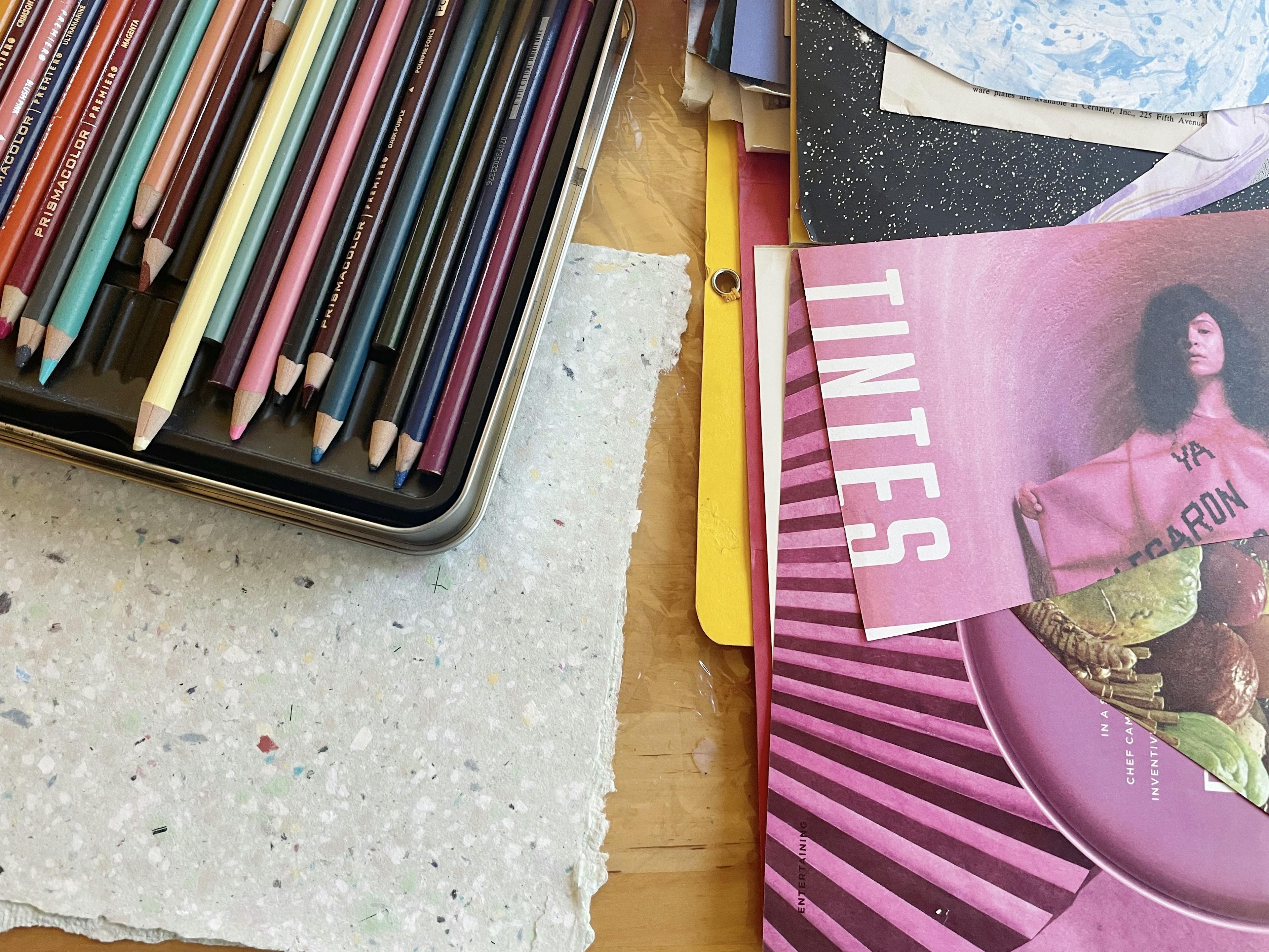 A box of colored pencils and stacks of magazines in artist Xochi Solis' studio.