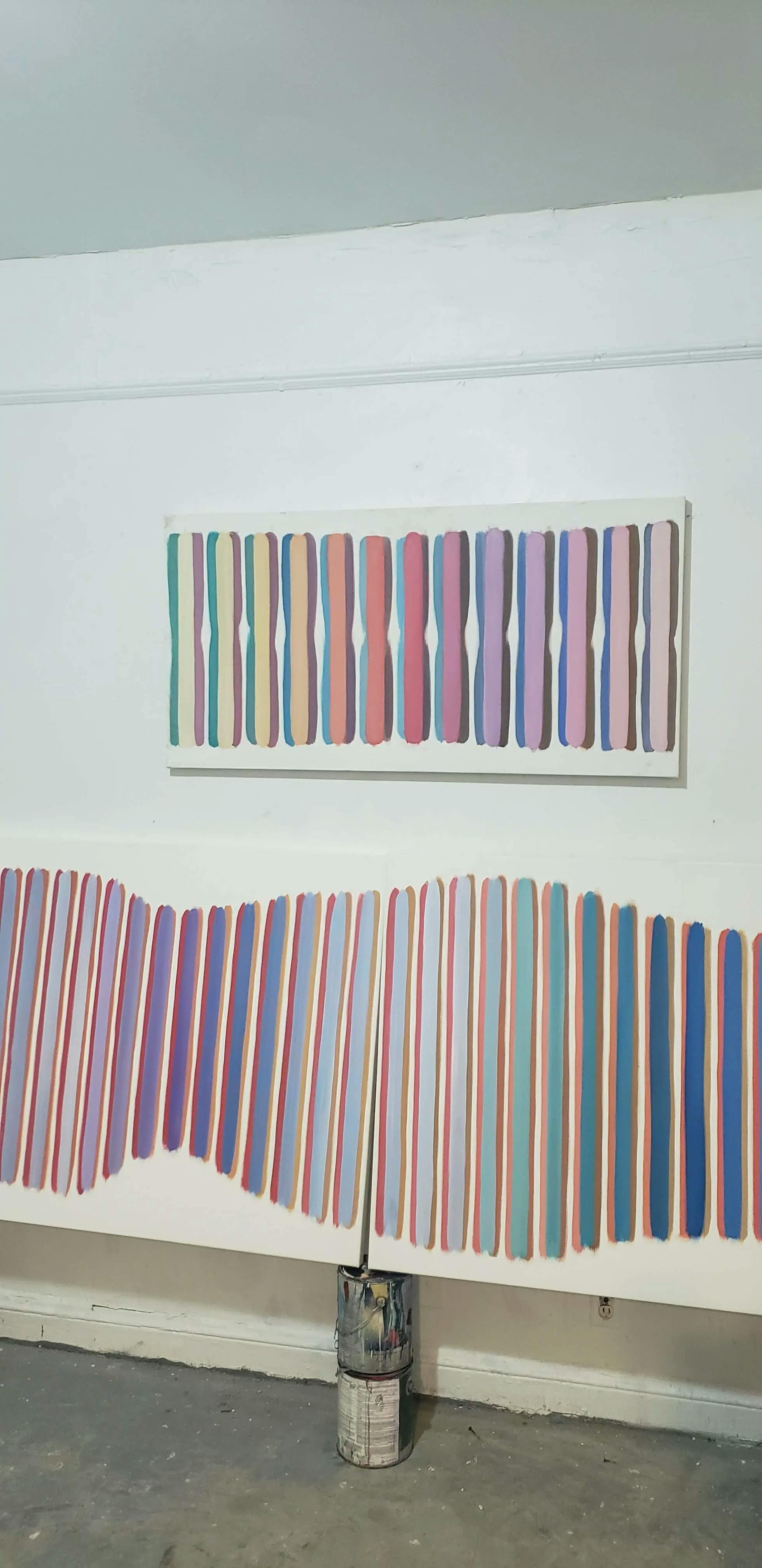 Three multicolored paintings by John Platt in his studio. 