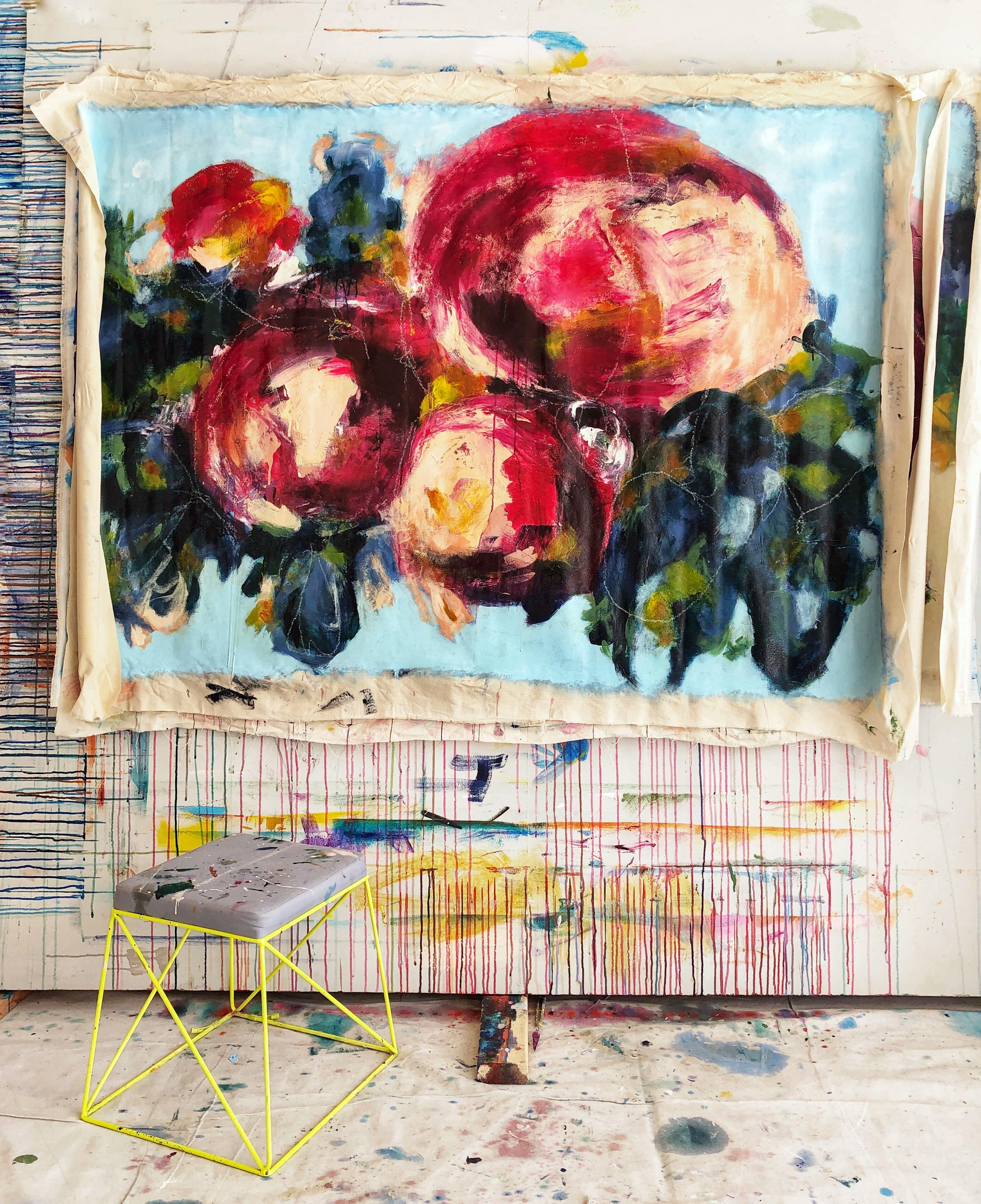 An abstract floral painting with drips by artist Elisa Gomez in her studio.