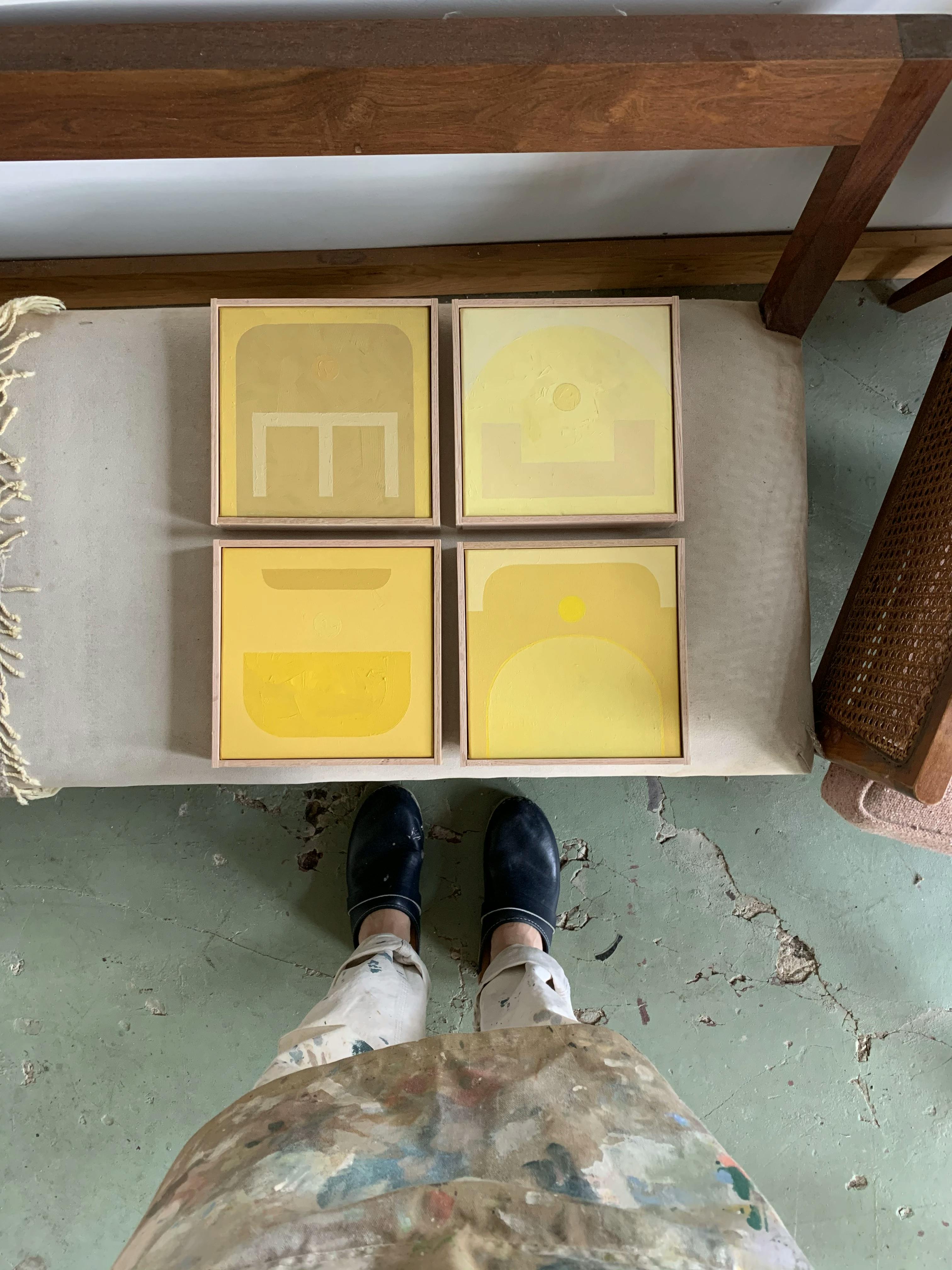 A grid of four small yellow paintings by artist Fitzhugh Karol.