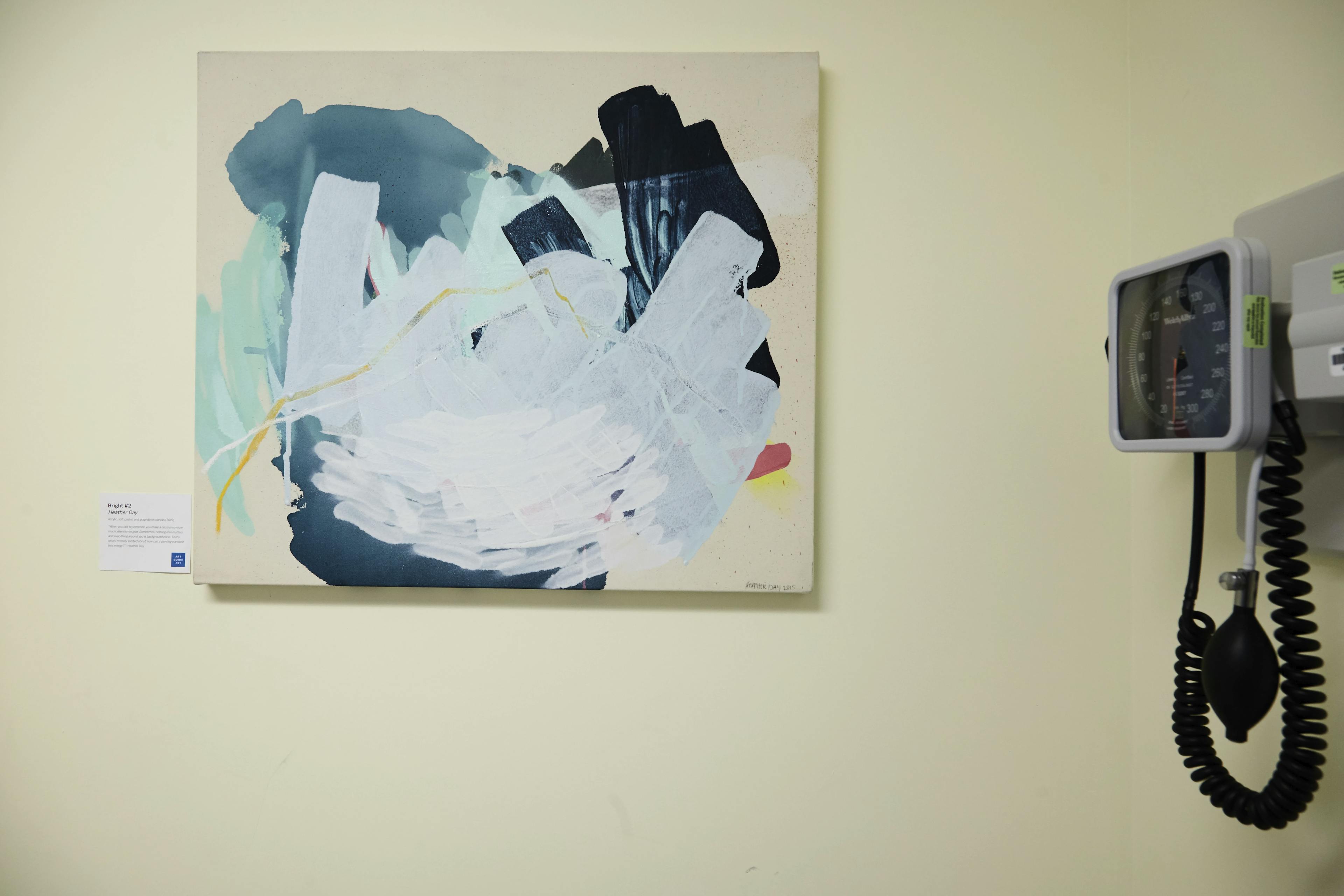 Gestural abstract painting by artist Heather Day installed on a wall next to a blood pressure machine at a hospital.