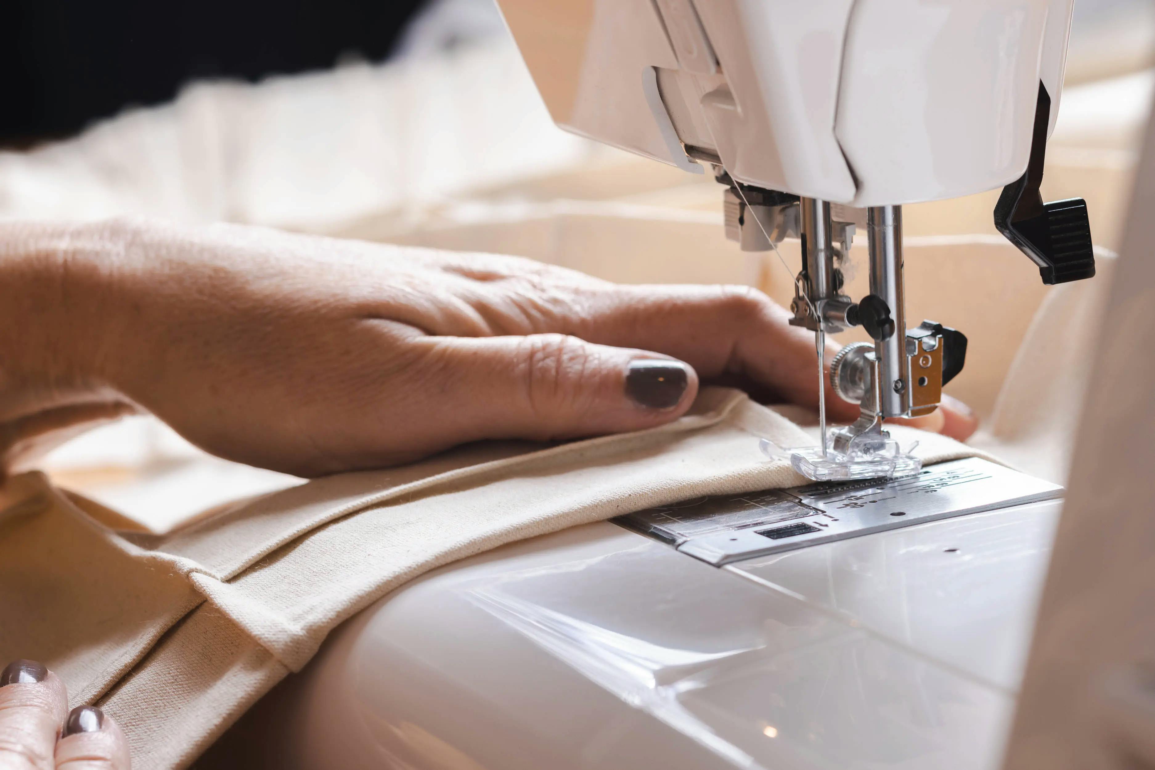Close-up of artist Nicole Anastas using a sewing machine in her studio.