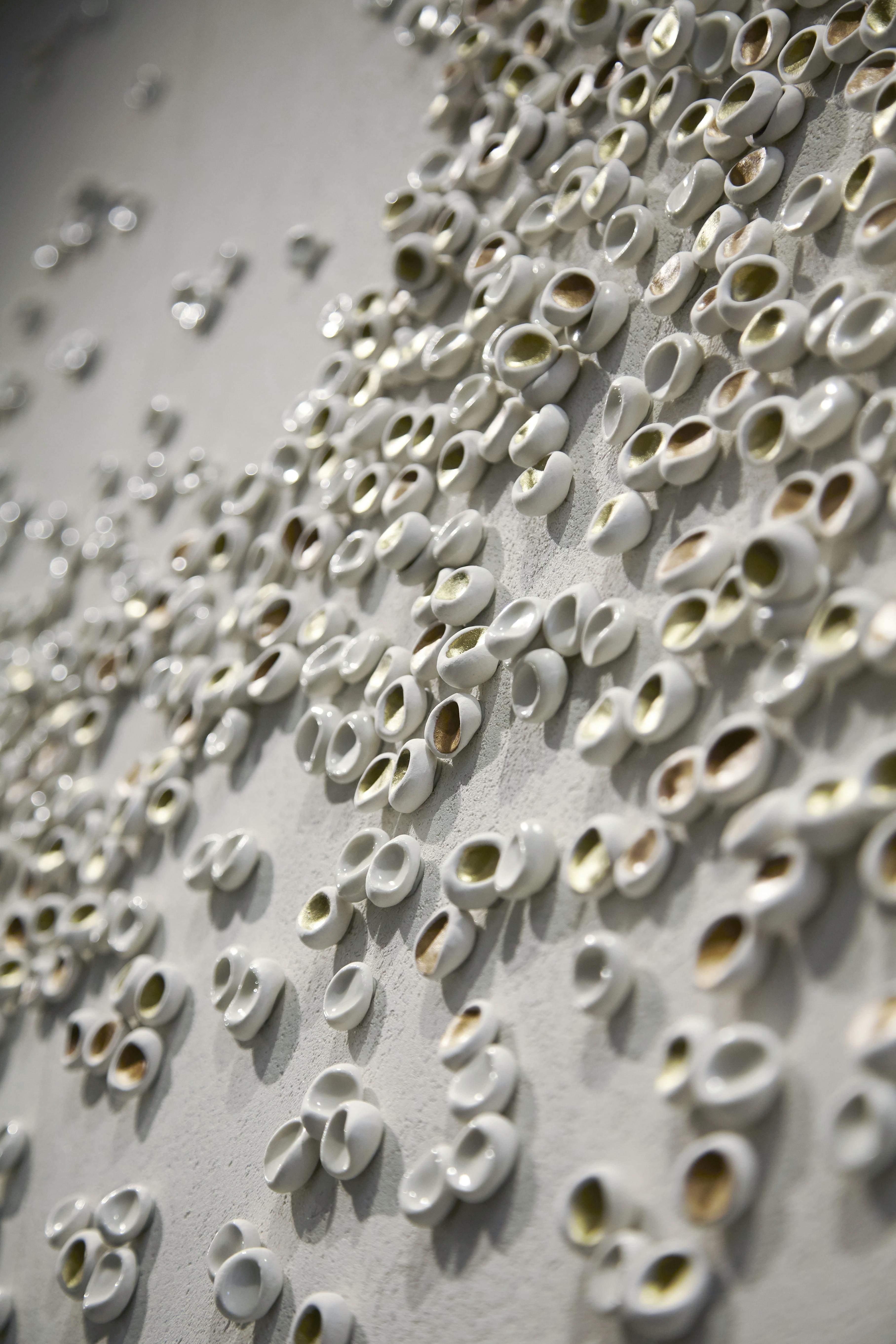Close up of hand-sculpted porcelain pieces with gold leaf by artist Christina Watka.