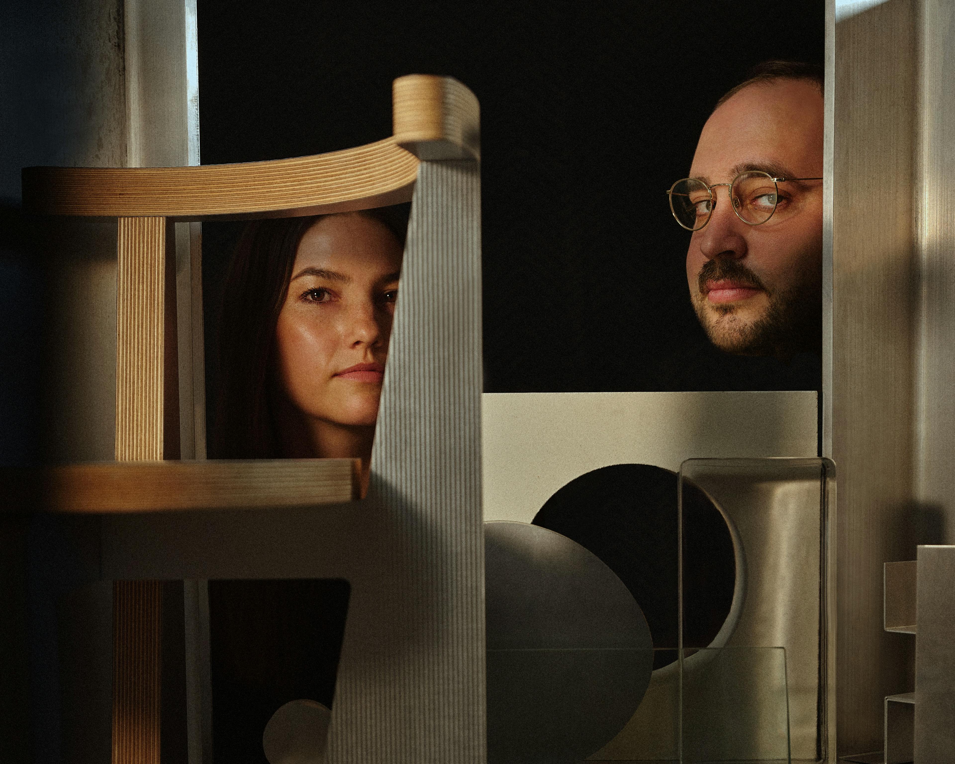Architects Michael Yarinsky and Kelley Perumbeti in the shadows within crevices of modern furniture.