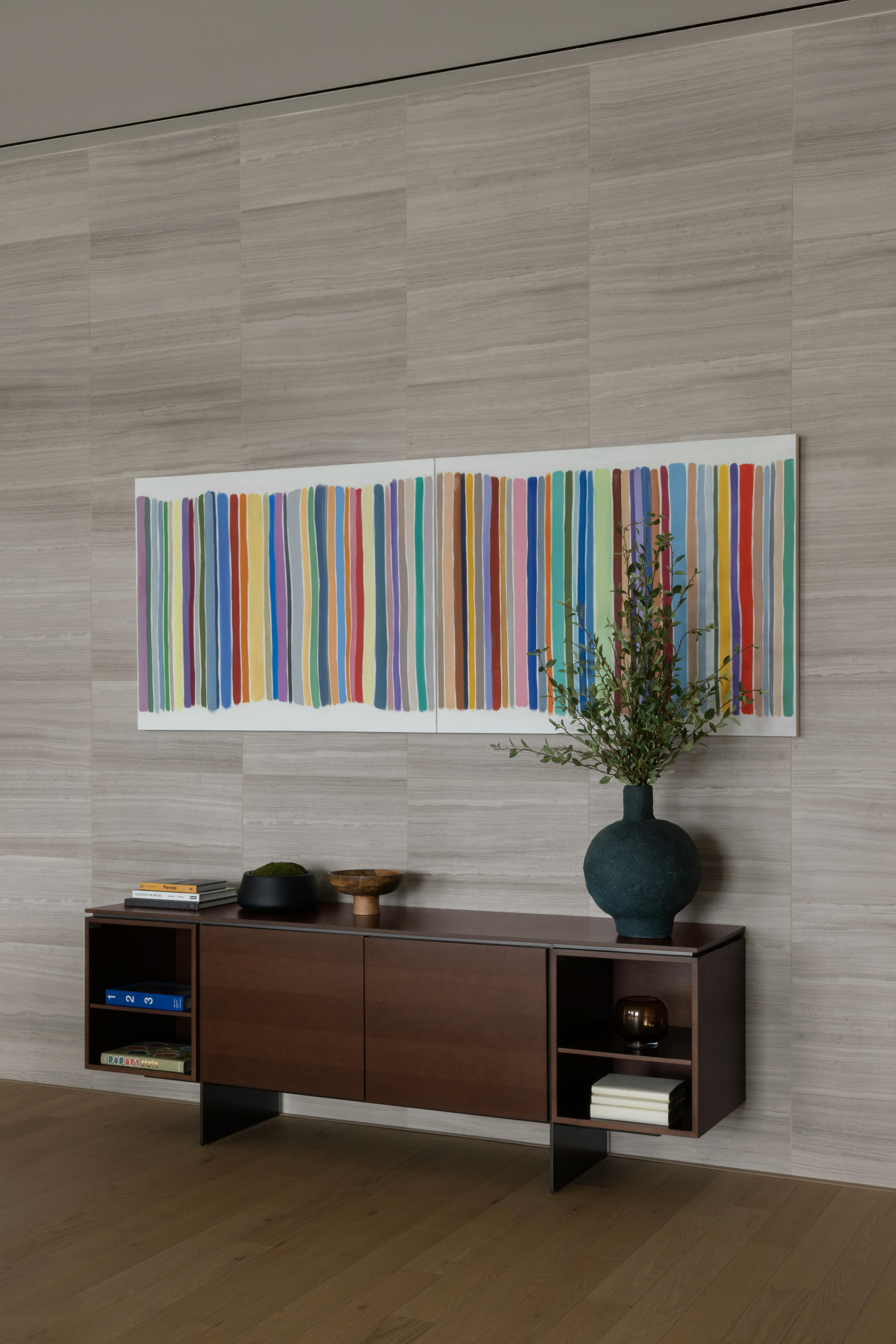 A diptych of repeating colorful lines by artist John Platt installed above a console table in Gotham Point.