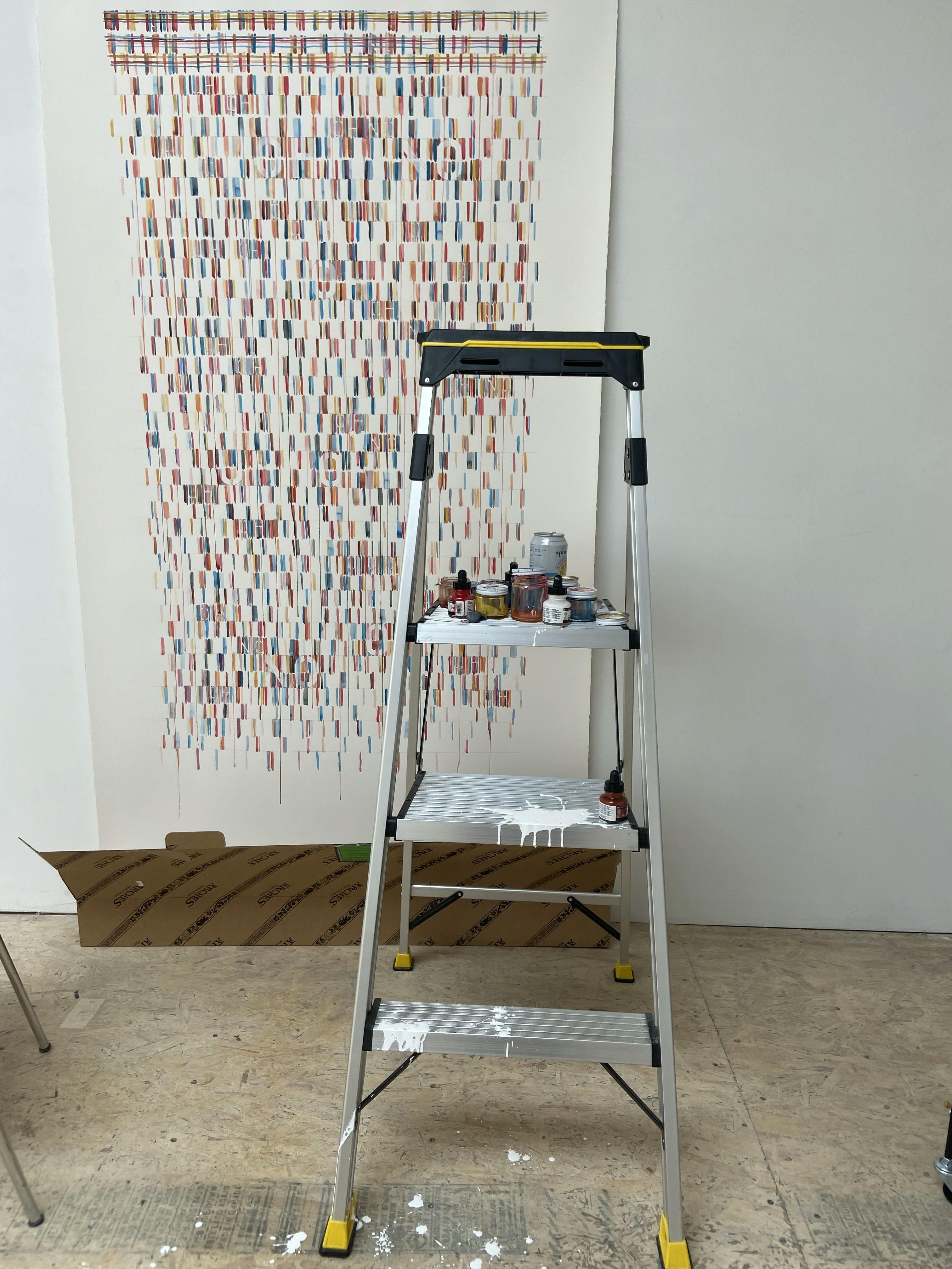 A ladder in front of a large, text-based work on paper in artist Gail Tarantino's studio.