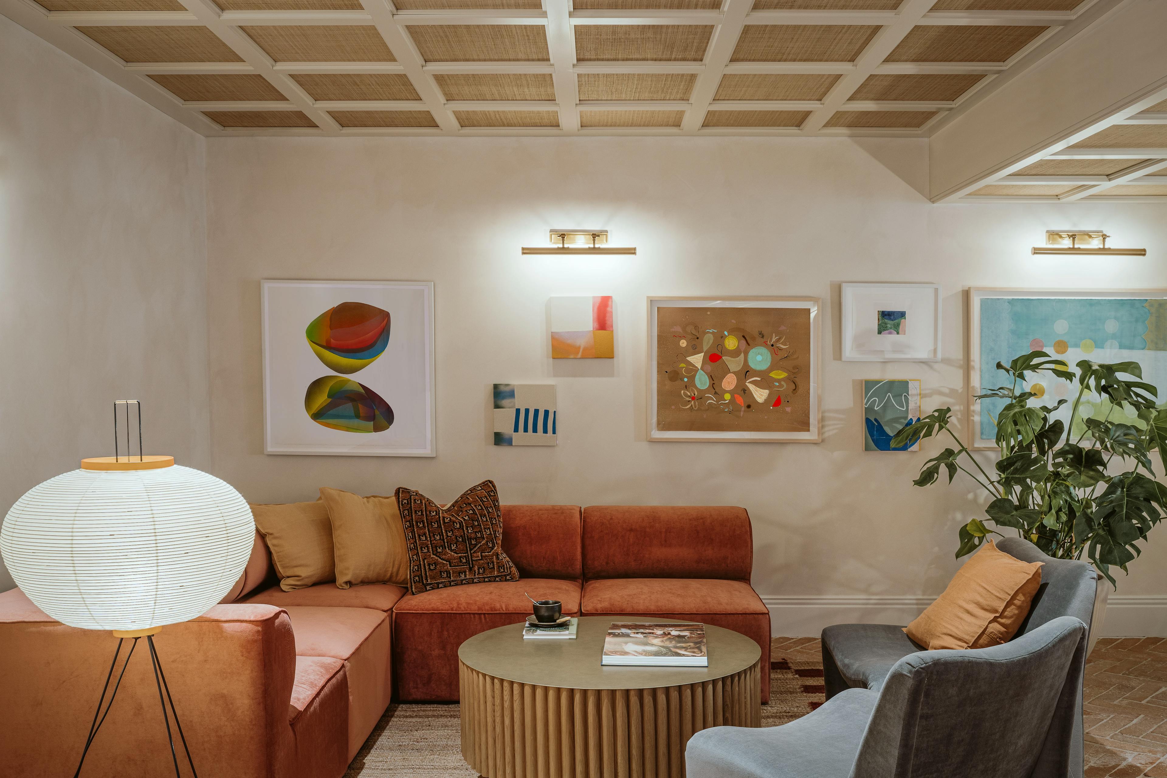 A gallery wall within a lounge area at the Chief London clubhouse, featuring different-sized artwork by artists Laura Berman, Anastasia Greer, Kayla Plosz Antiel, Misato Suzuki and Jessica Simorte.
