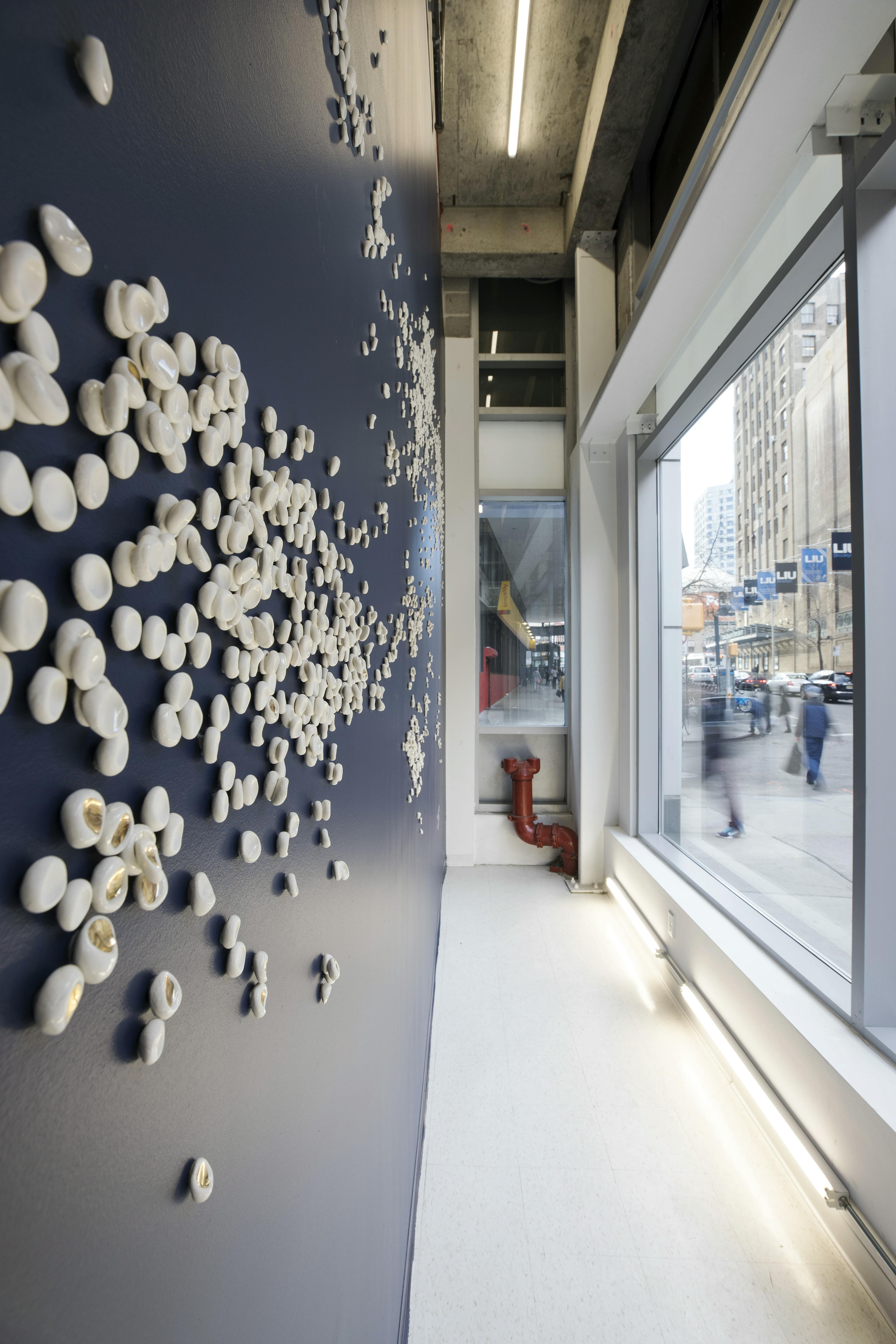 Close-up of individual white porcelain pieces, as part of a custom wall installation by artist Christina Watka.