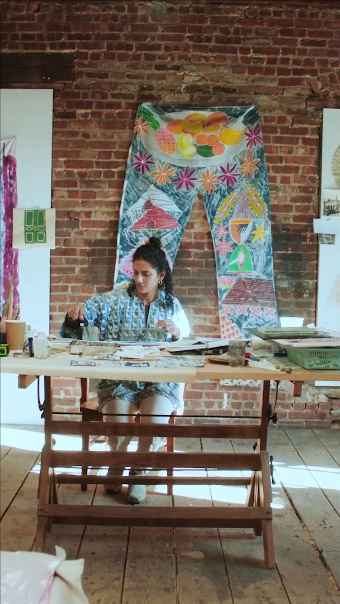 Padma Rajendran sitting at a table in her studio. 