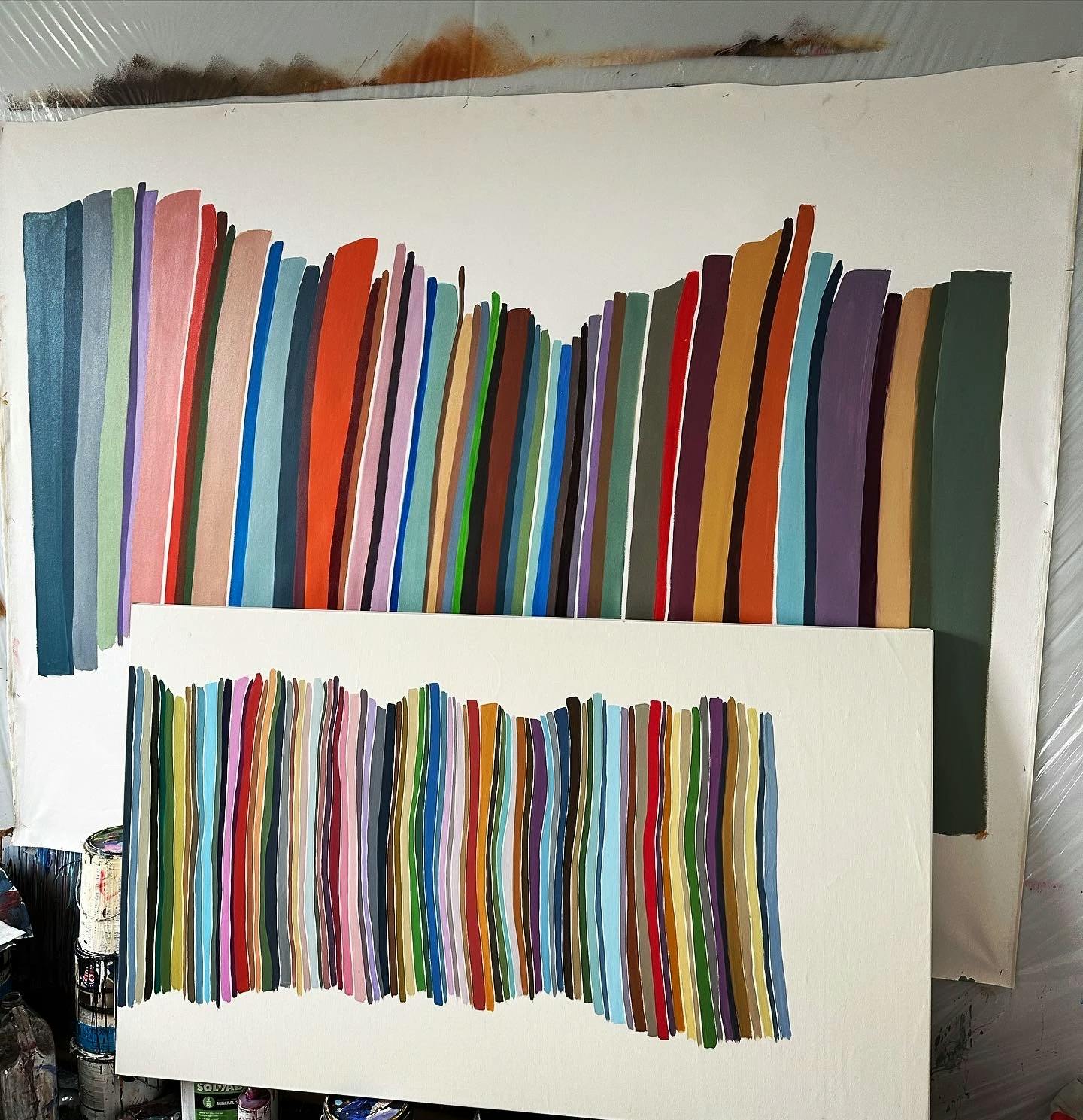 Two multicolored paintings by John Platt in his studio. 