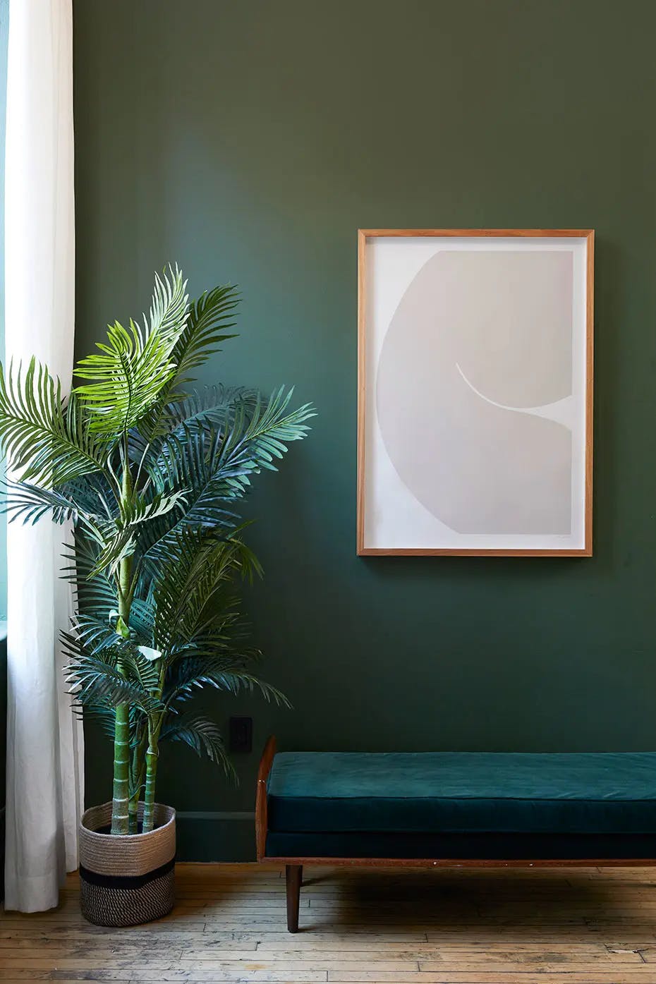 Framed, neutral silhouette screen print by artist Caroline Walls installed on a green wall over a bench at Chief Tribeca.
