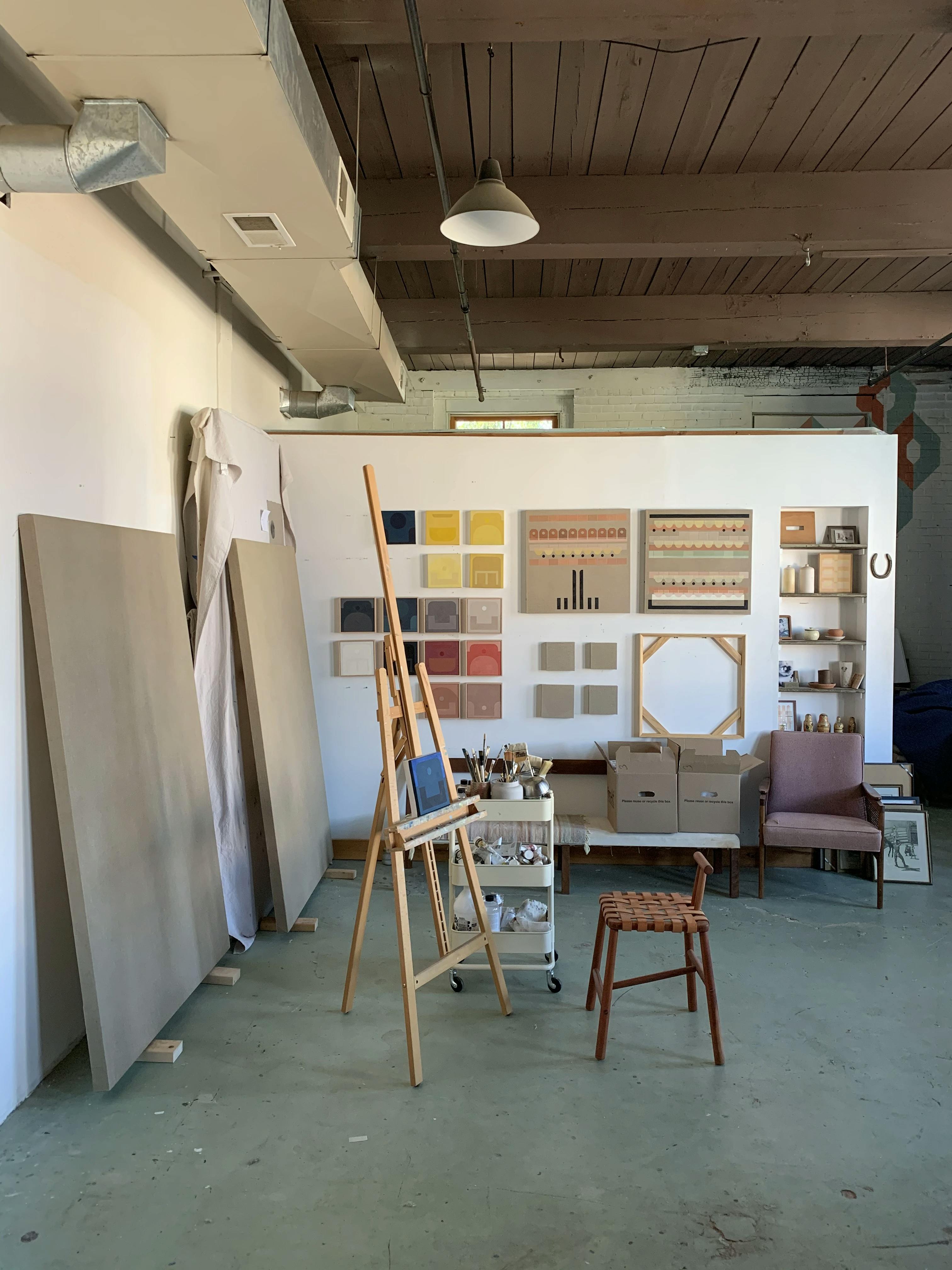 Easels and paintings installed on the wall within artist Carla Weeks' studio.