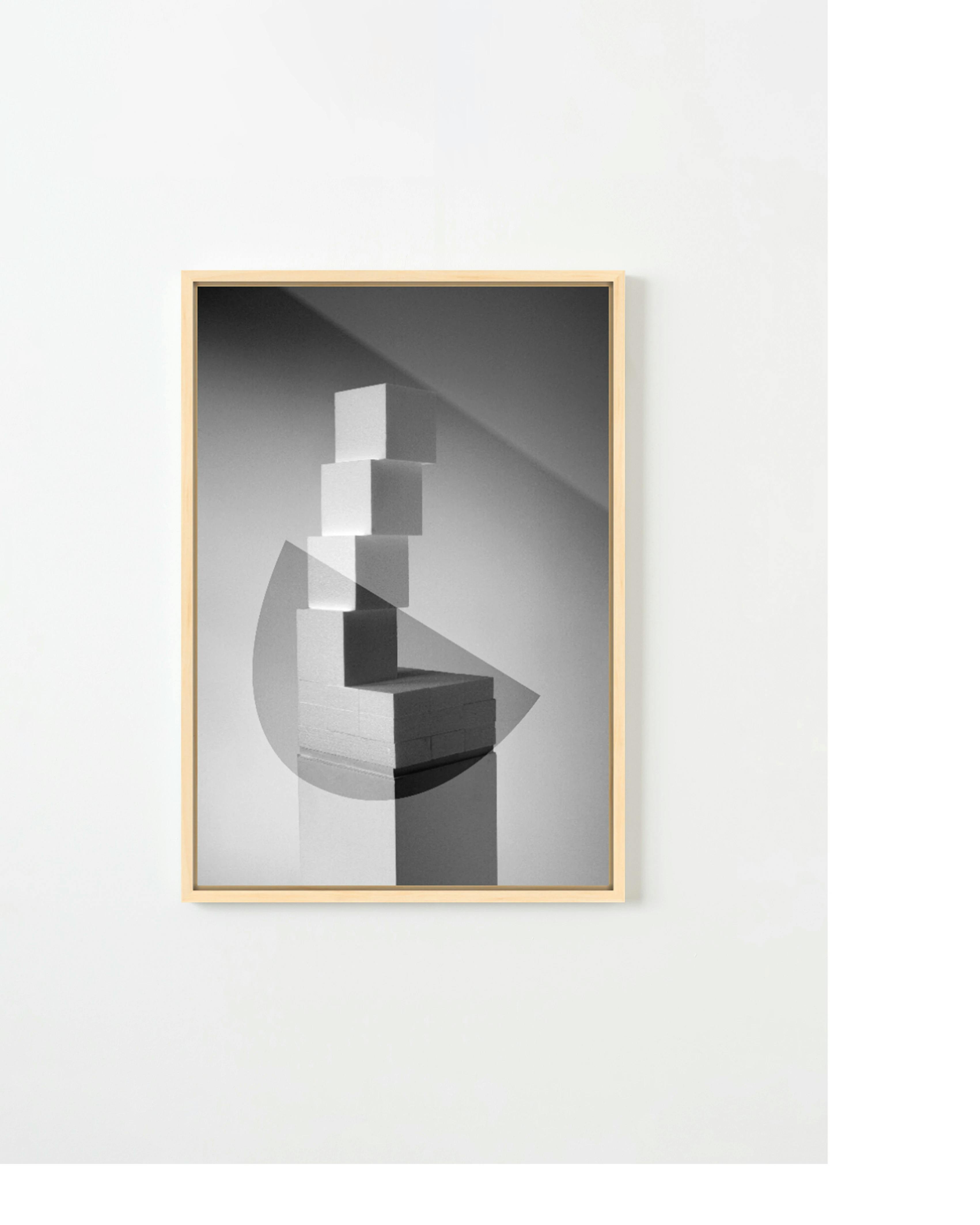 A framed, black and white print by artist Adam Ryder of a geometric tower.
