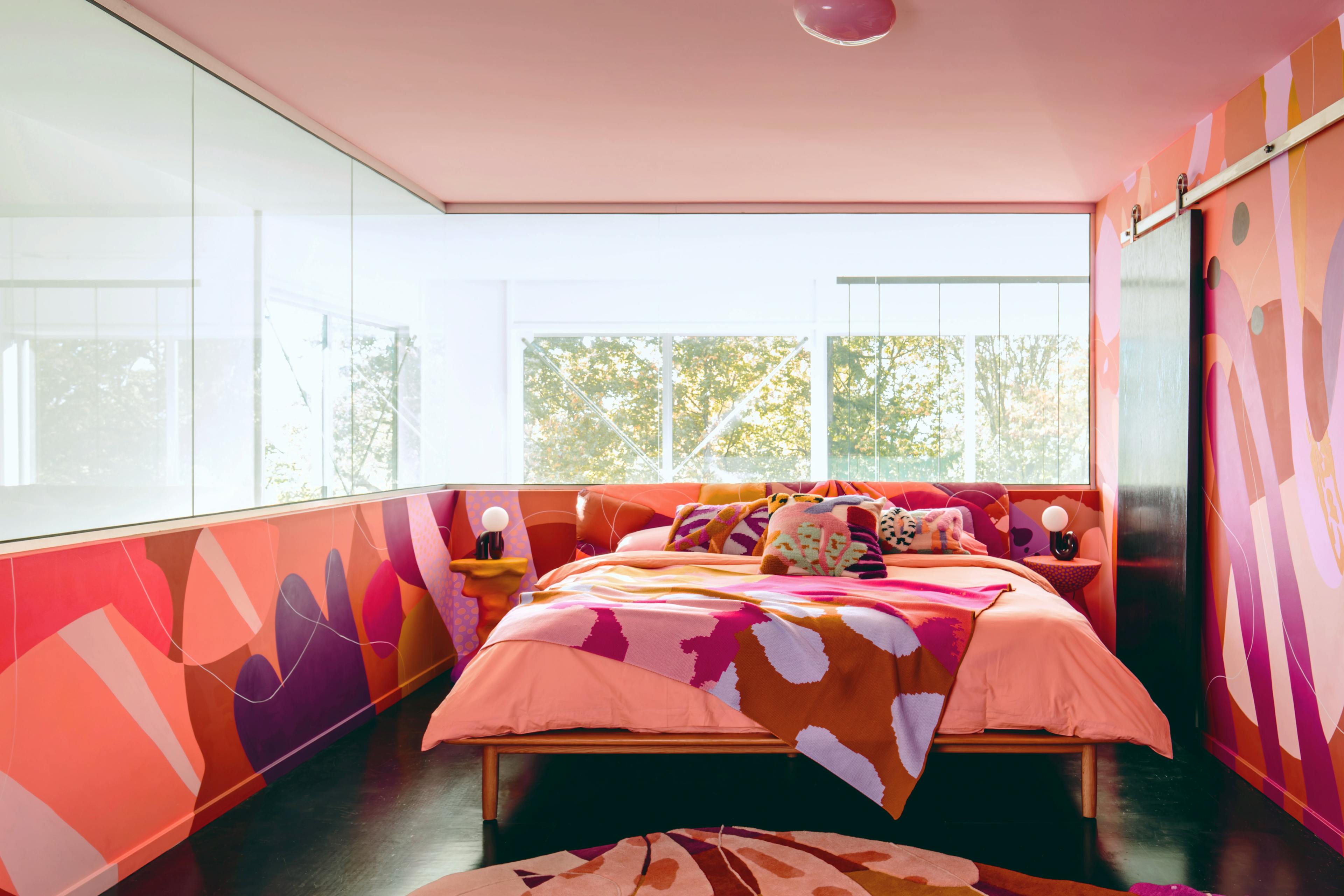 Alex Proba's bedroom with colorful wall murals and bedding.