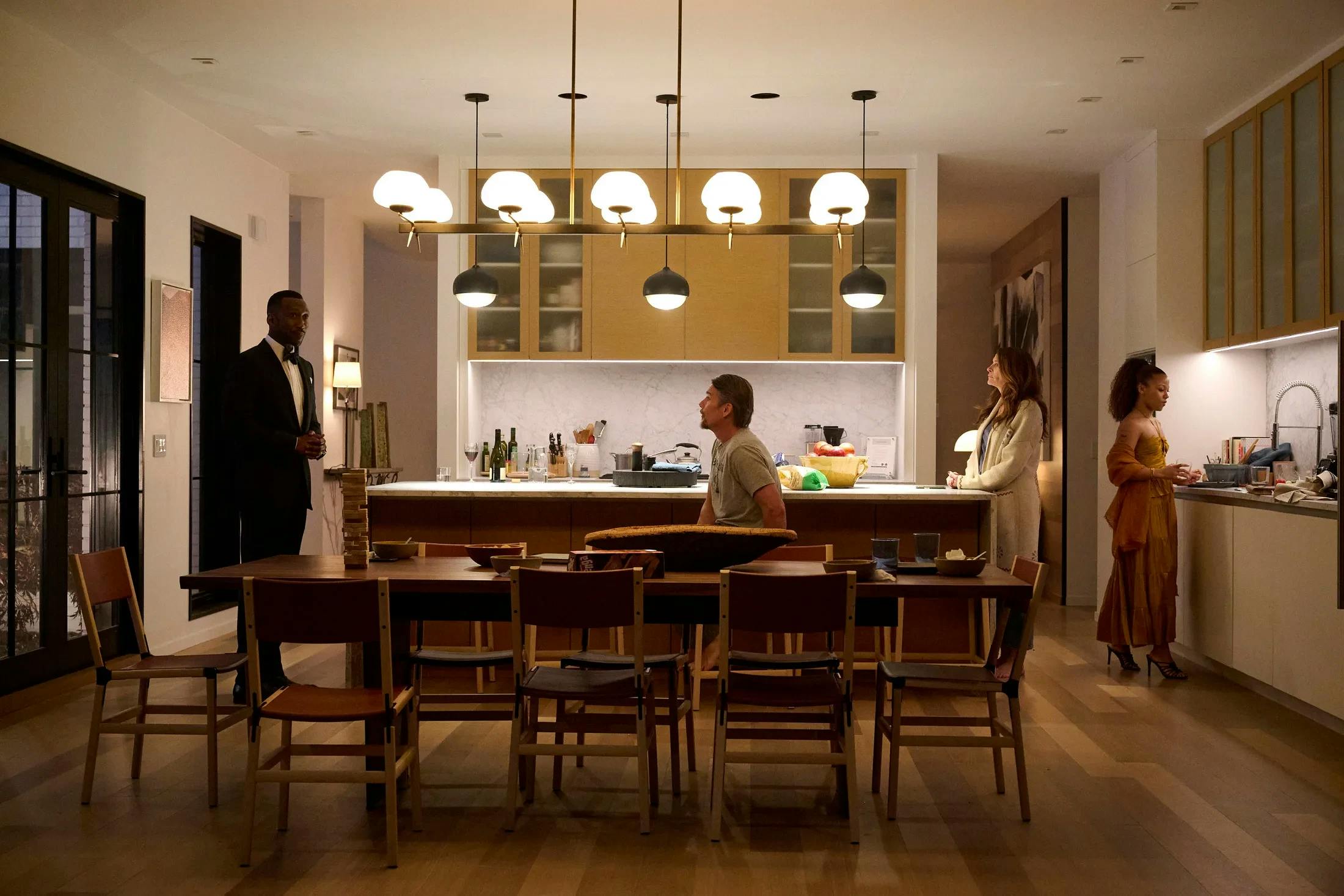  A film still from the Netflix movie, Leave the World Behind, set in a modern kitchen with actors Julia Roberts, Mahershala Ali, Ethan Hawke, & Myha'la Jael Herrold.