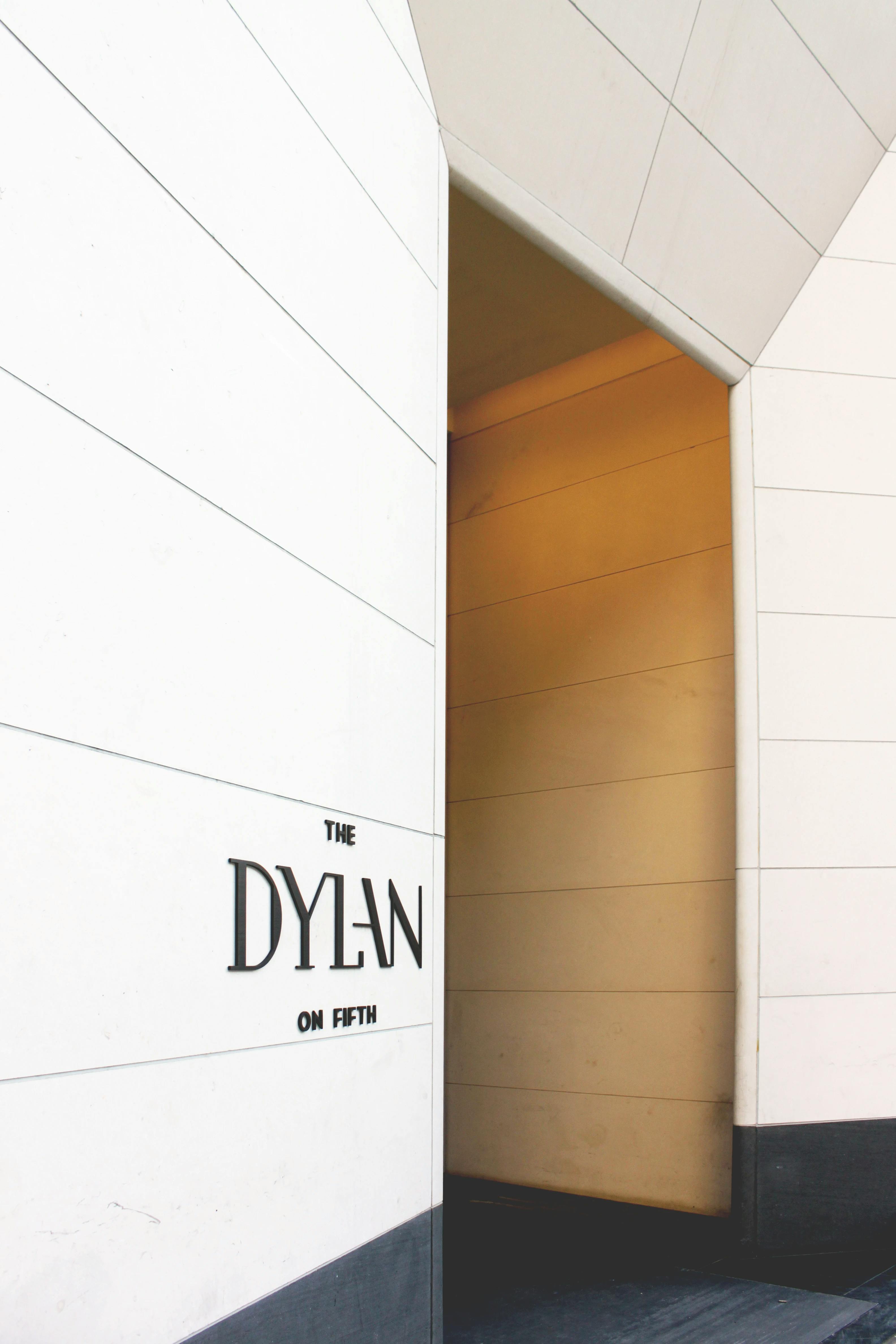 Text on a white wall that says "The Dylan on Fifth" in the lobby of a residential building.