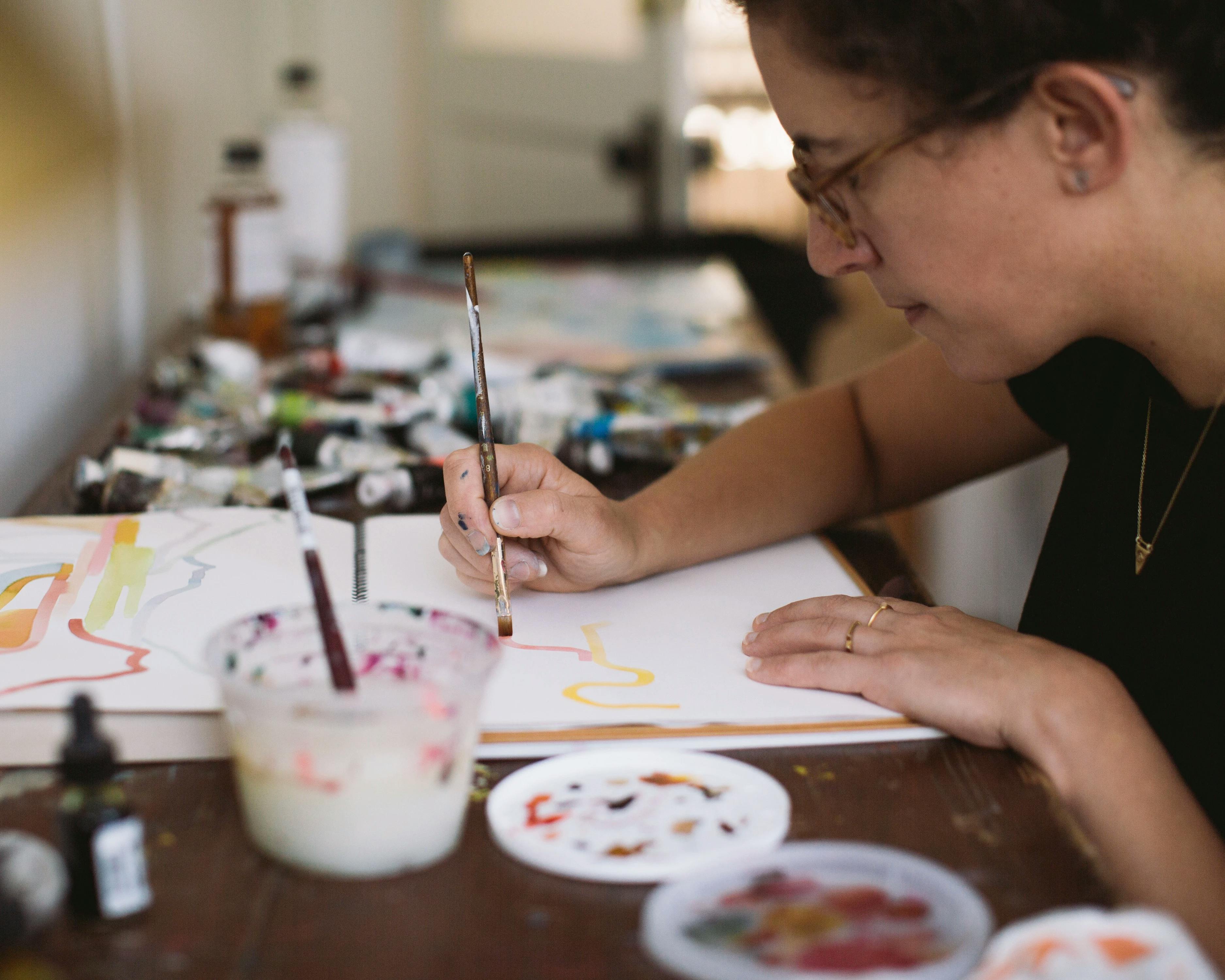 Artist Aliza Cohen painting in her studio.