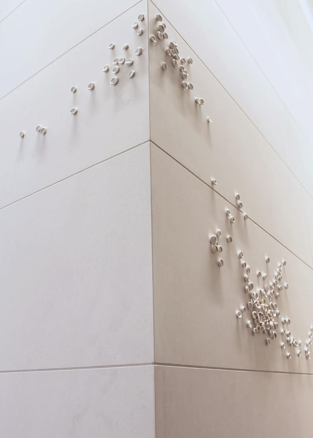 White porcelain installation on a white wall by artist Christina Watka. 