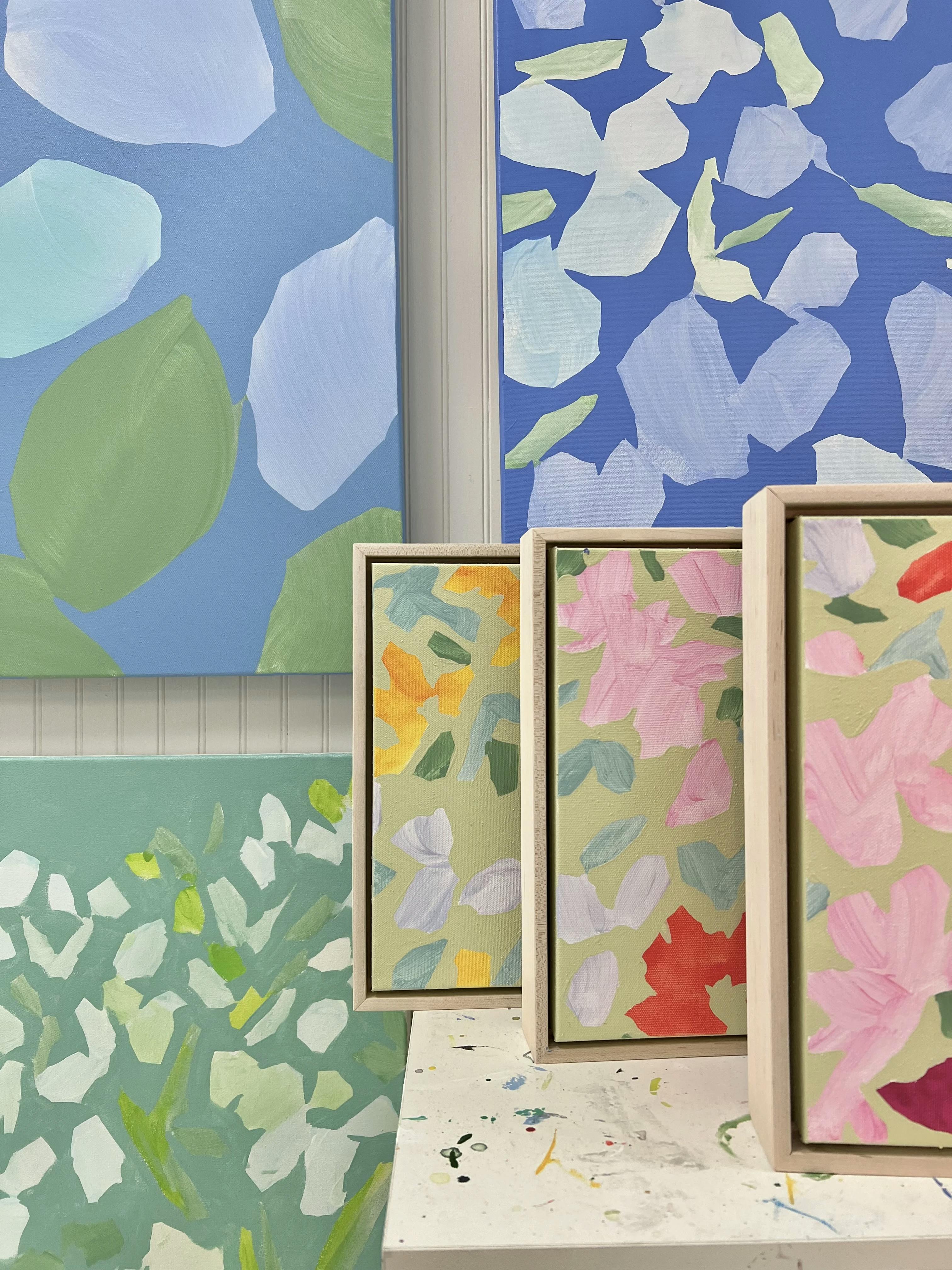 A close-up of different sized paintings with colorful, fragmented flowers by artist Kit Porter.