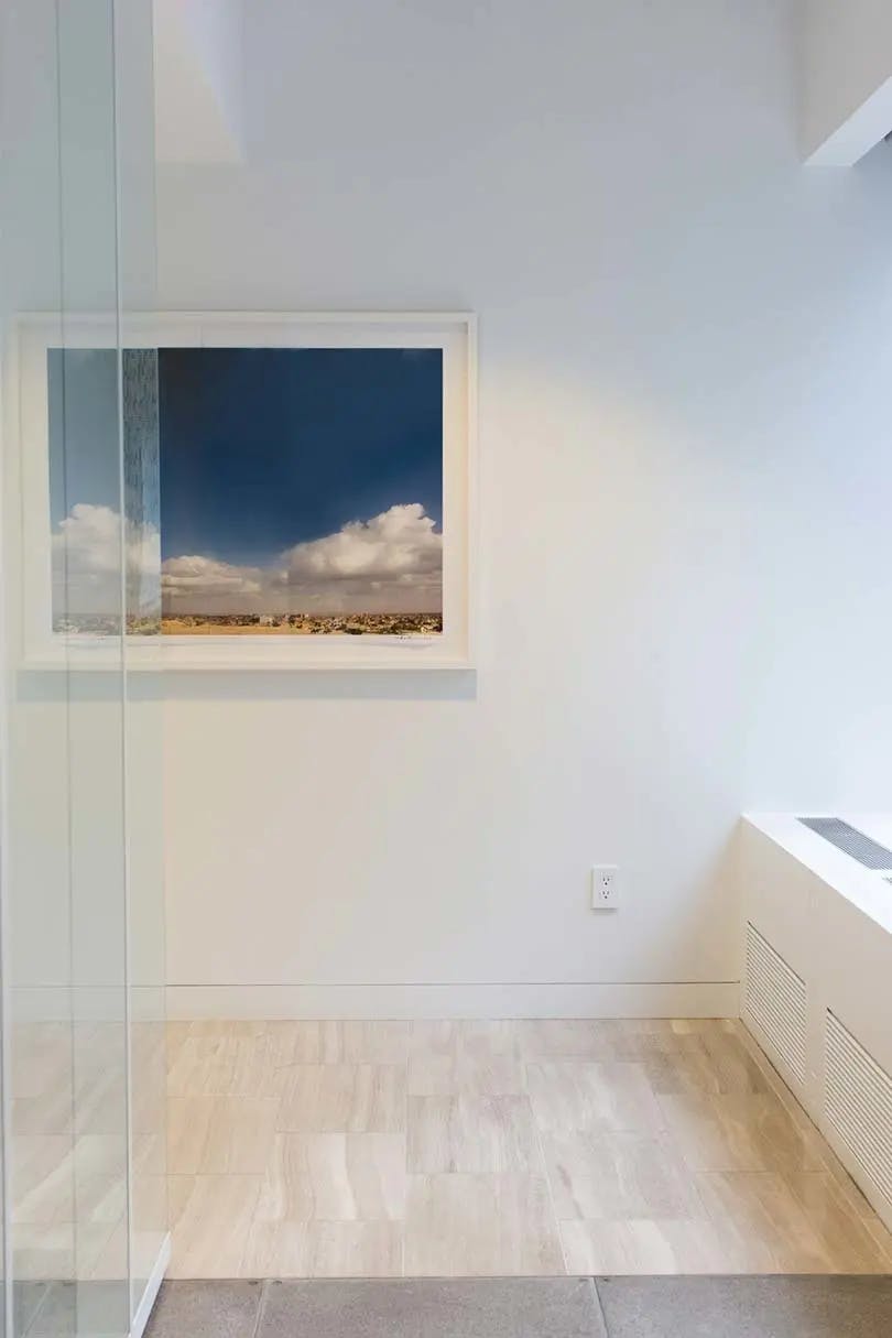 One large framed photograph of Giza, Egypt by artist Ashok Sinha installed on a white wall in a modern office building.
