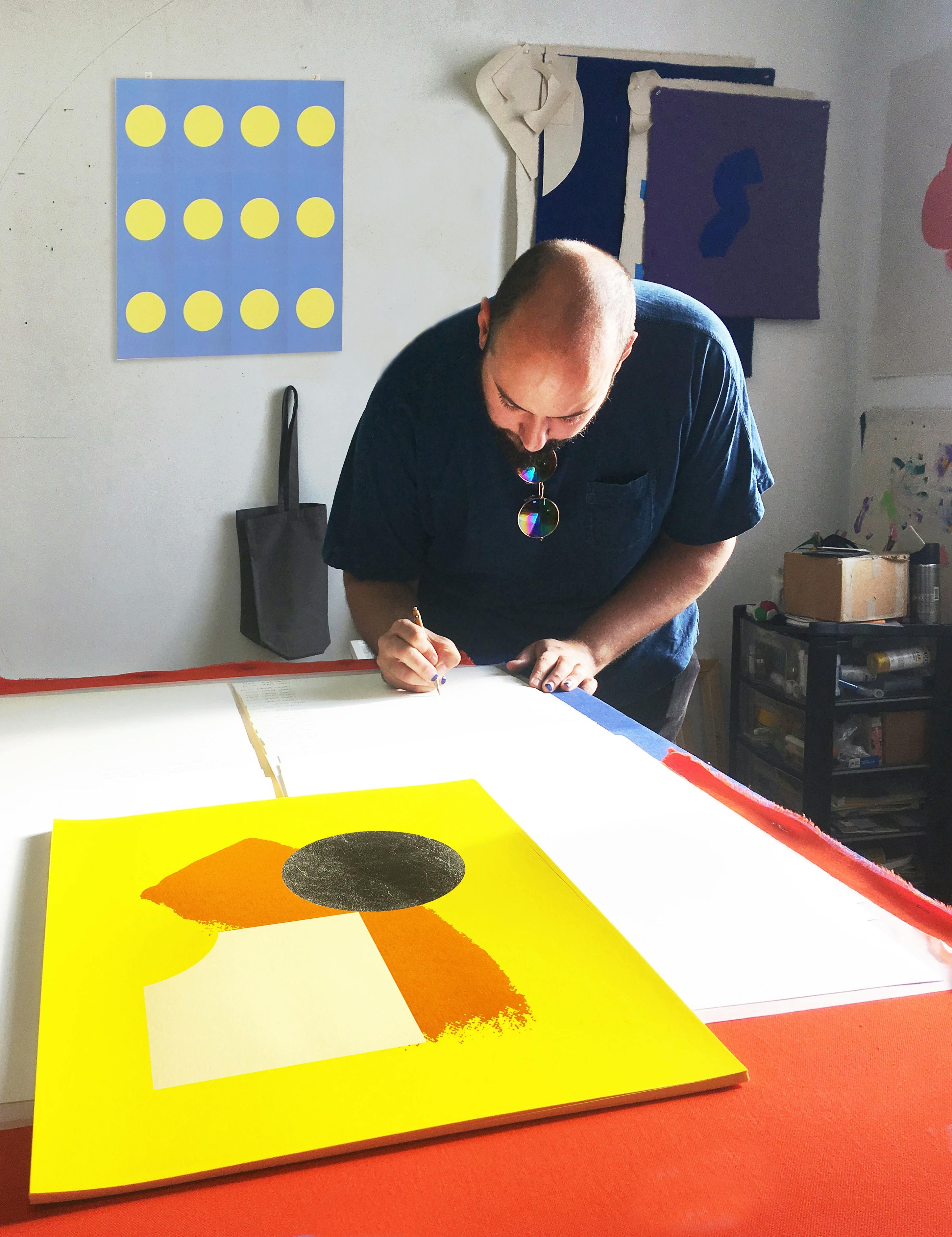 Artist Chad Kouri signing his print Opportunity for Reflection (Yellow).