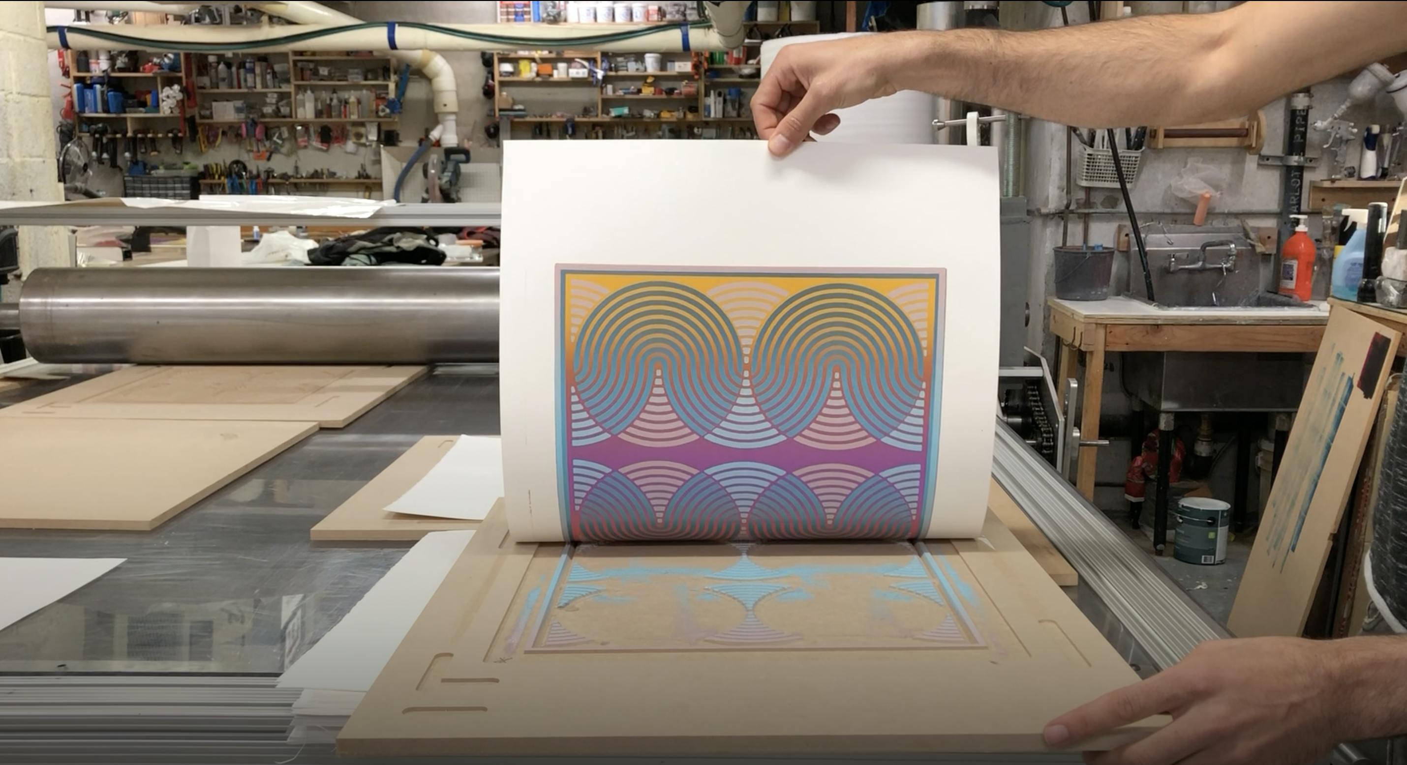 Artist Matt Neuman creating a printed, geometric work in his studio.