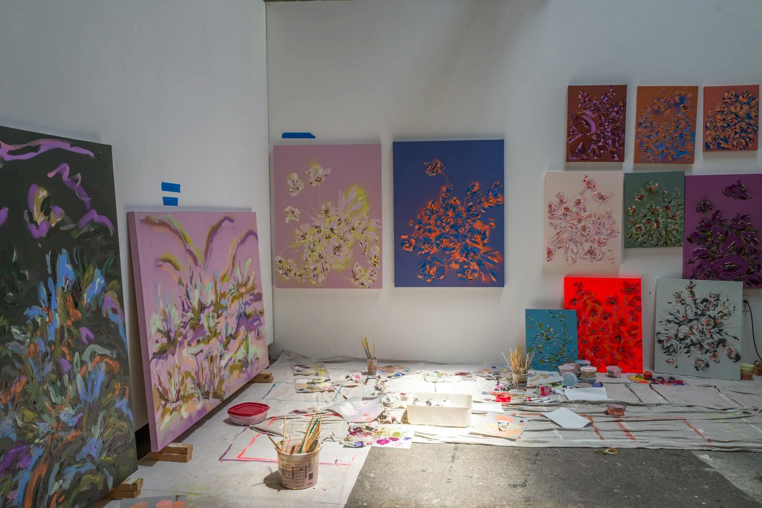 Artist Erin Lynn Welsh's studio filled with colorful floral paintings. 