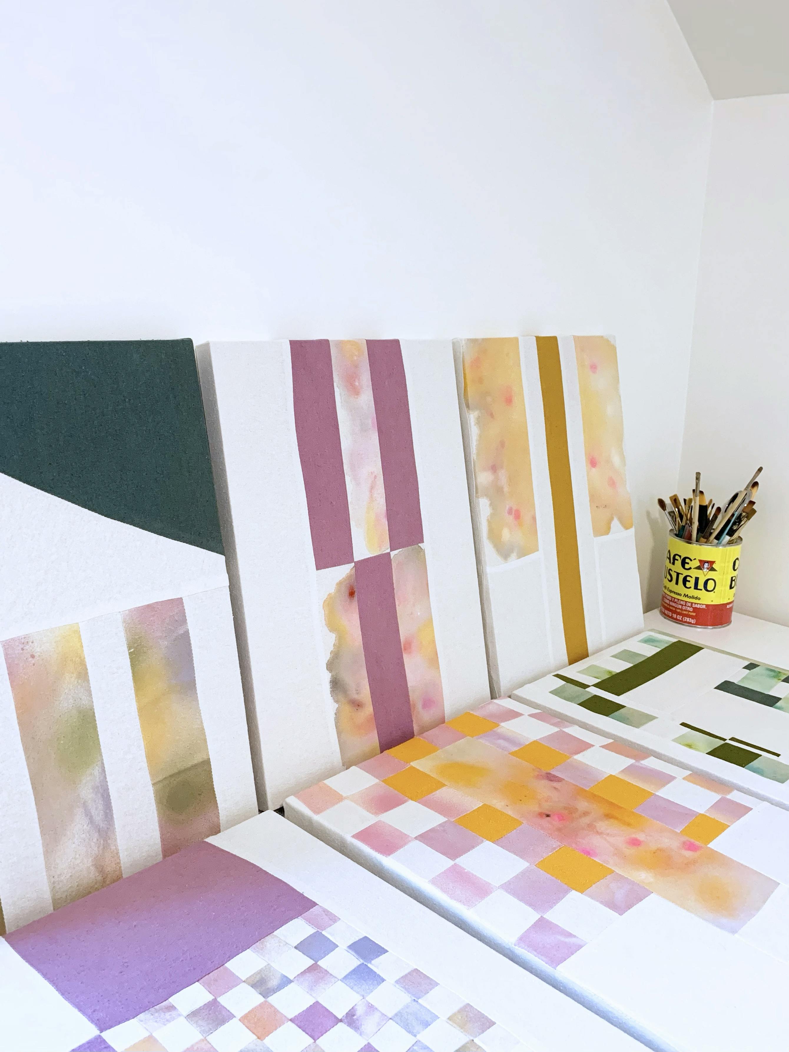 Patchwork pieces with colorful gradients and checkered patterns by artist Anastasia Greer in her studio.