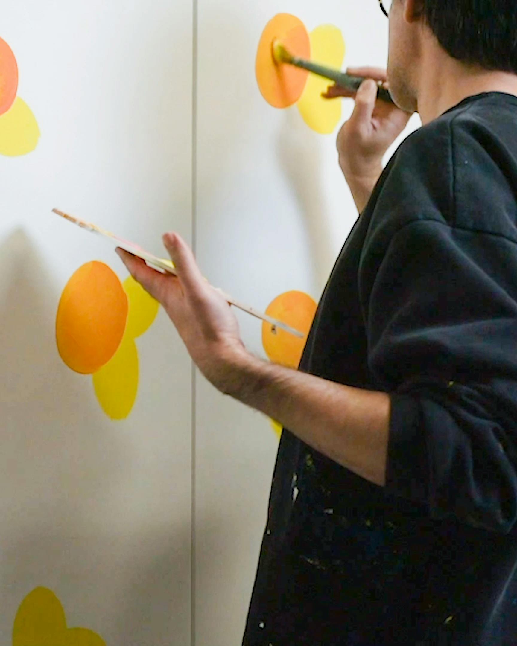 Artist Erin D. Garcia working on painting of oranges for exhibition Group 5