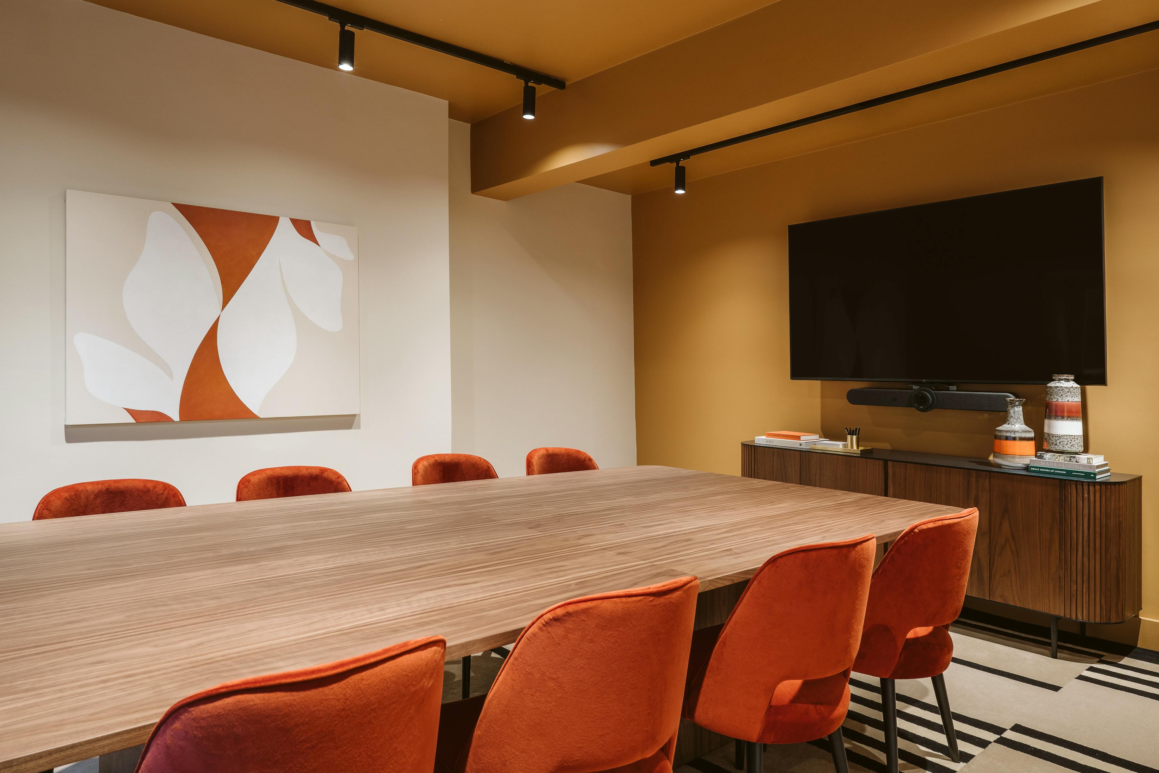 An abstract, terracotta and white floral painting by artist Senem Oezdogan installed on a white wall within a boardroom at the Chief London clubhouse.
