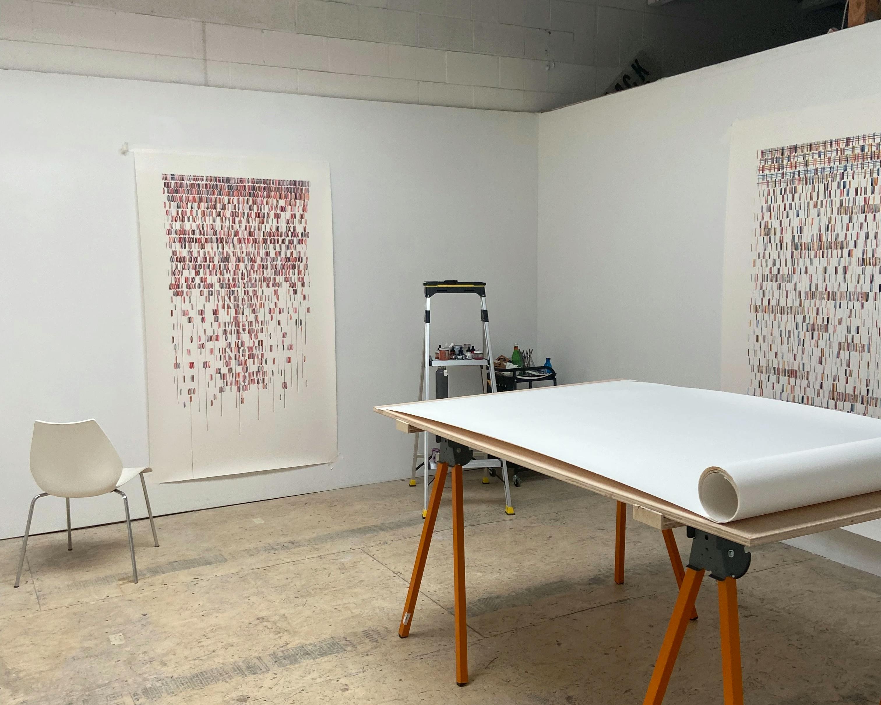 Artist Gail Tarantino's studio with large text-based works on paper installed on white walls.