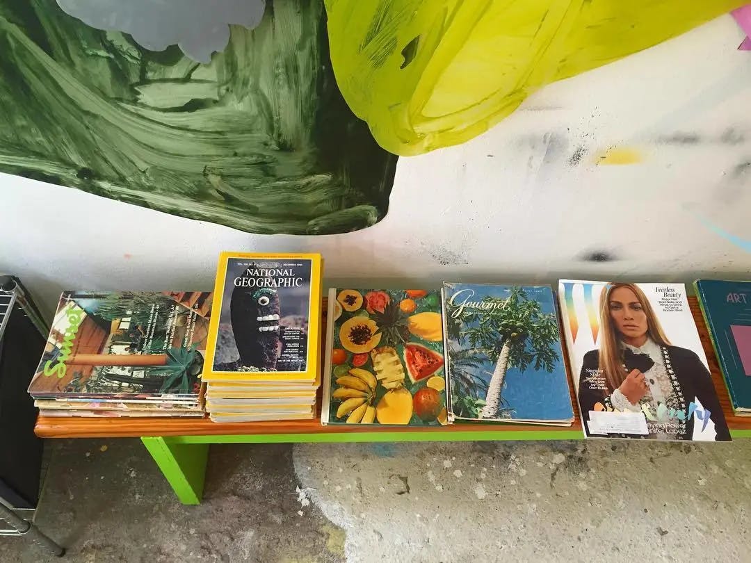 Stacks of books and magazines on a lime green bench in artist Xochi Solis' studio.