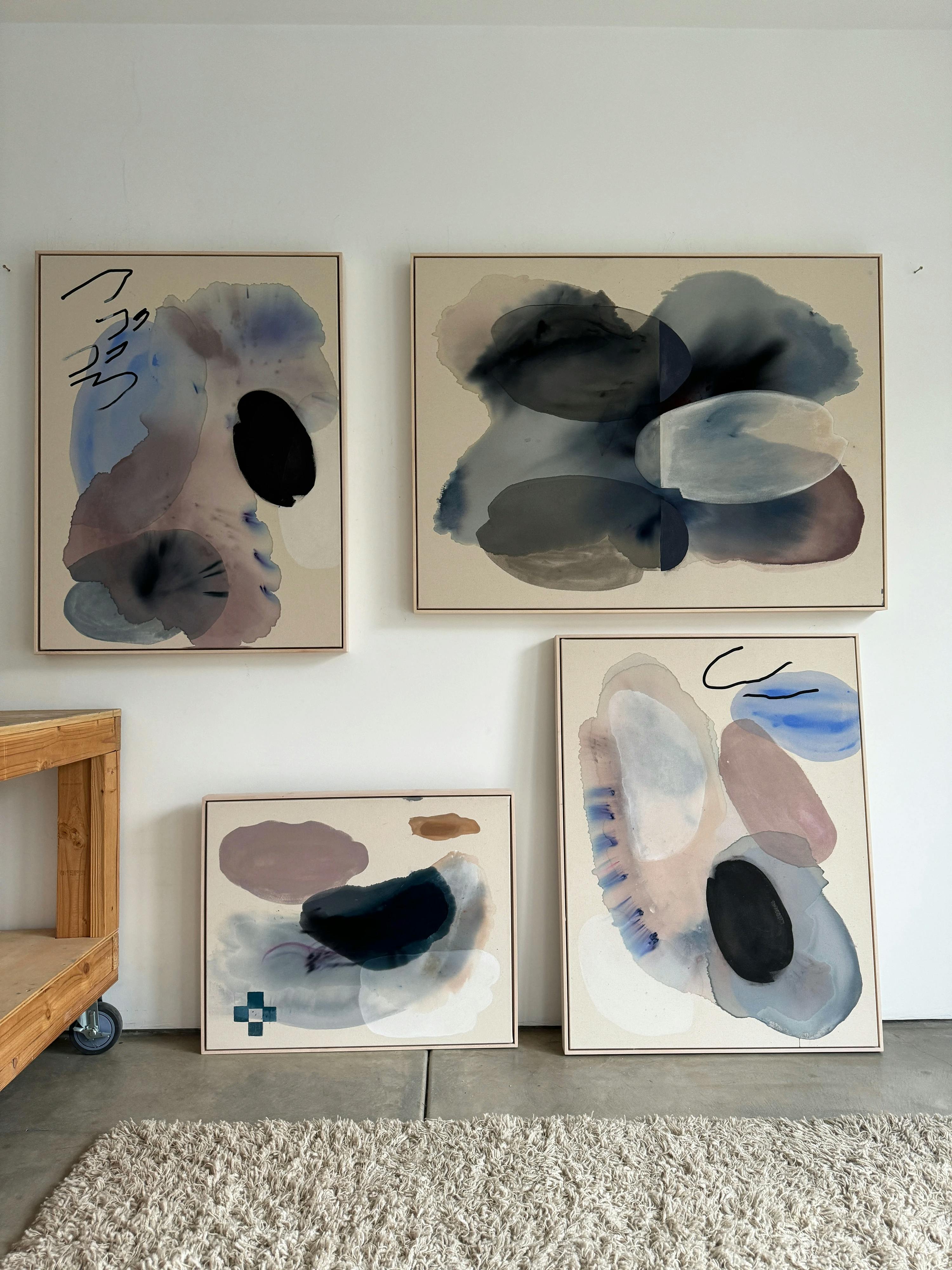 Four abstract, gestural paintings of various sizes by artist Karina Bania installed in her studio.