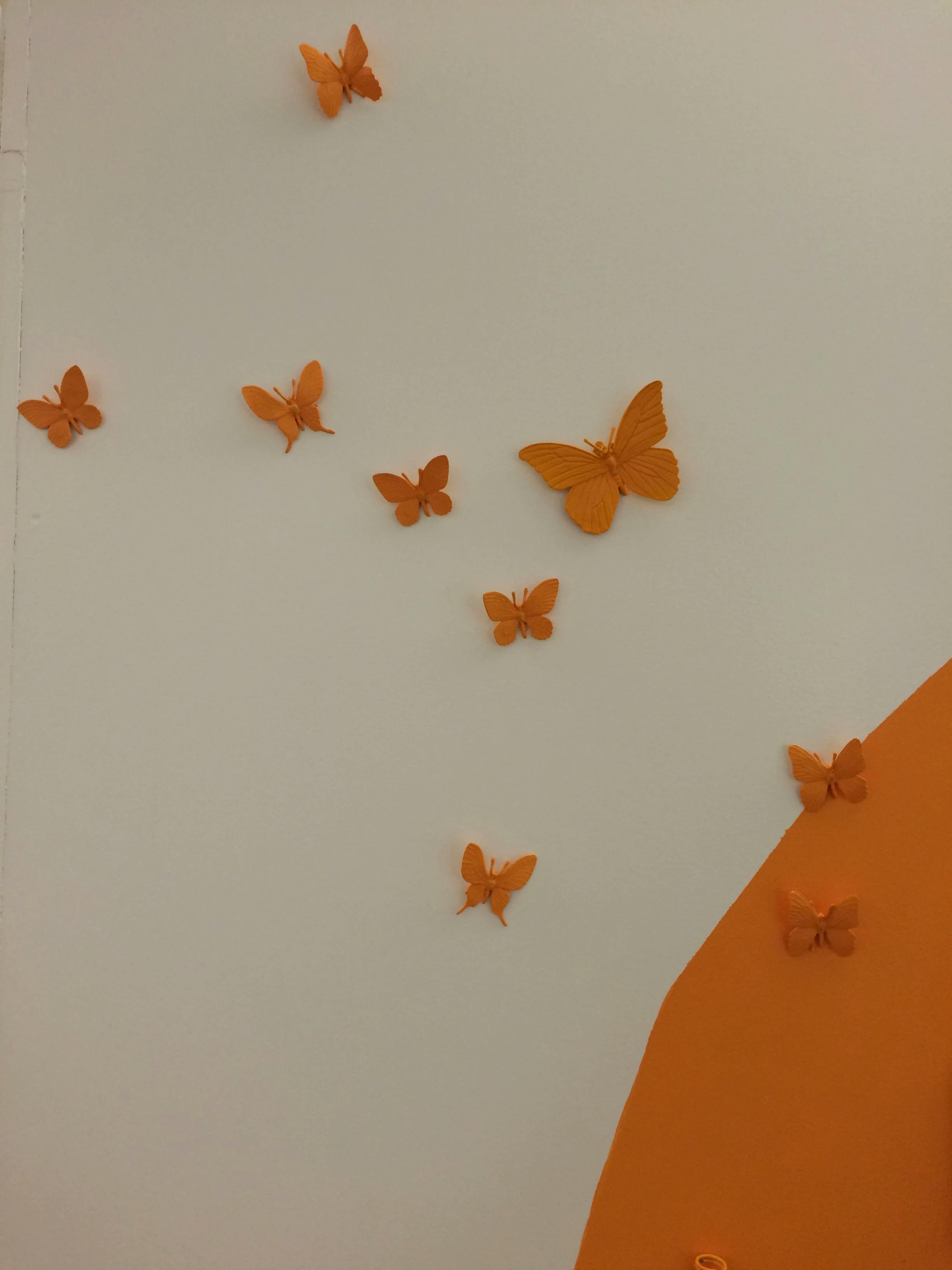Orange butterflies as part of a custom wall installation by artist Christina Watka.