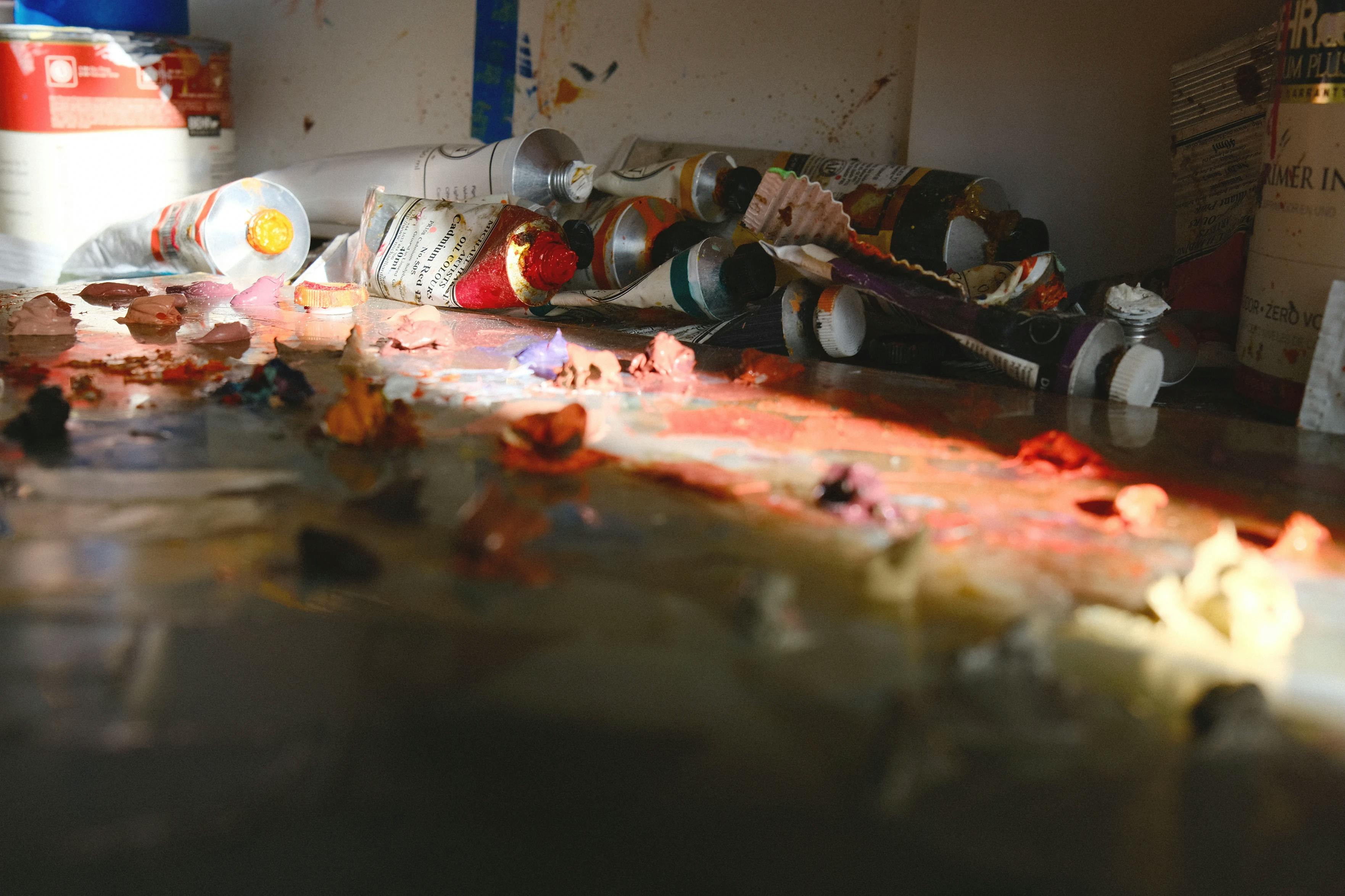 Paint bottles and smudges in a beam of light in Adrian Kay Wong's studio. 