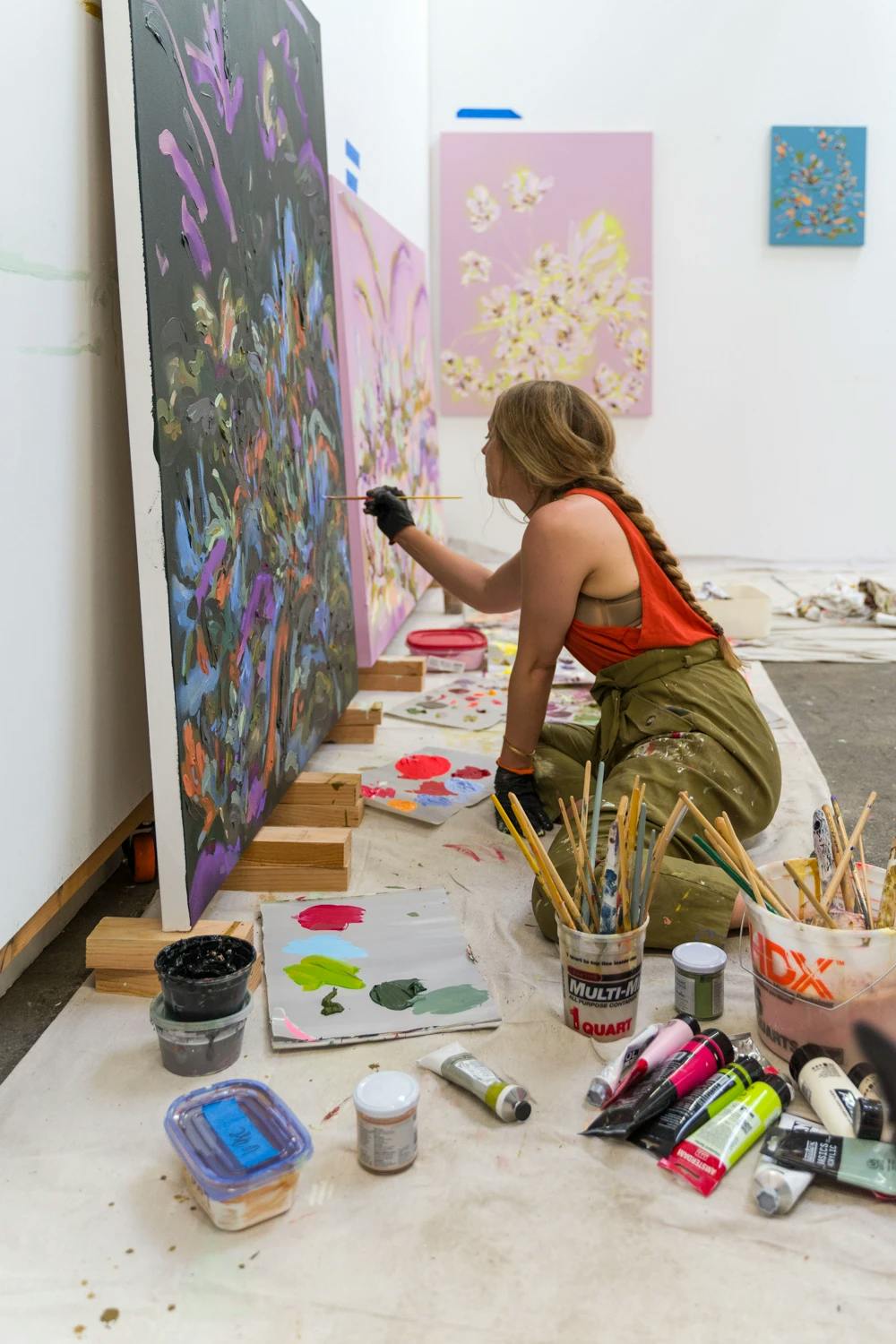 Artist Erin Lynn Welsh working on two floral paintings.