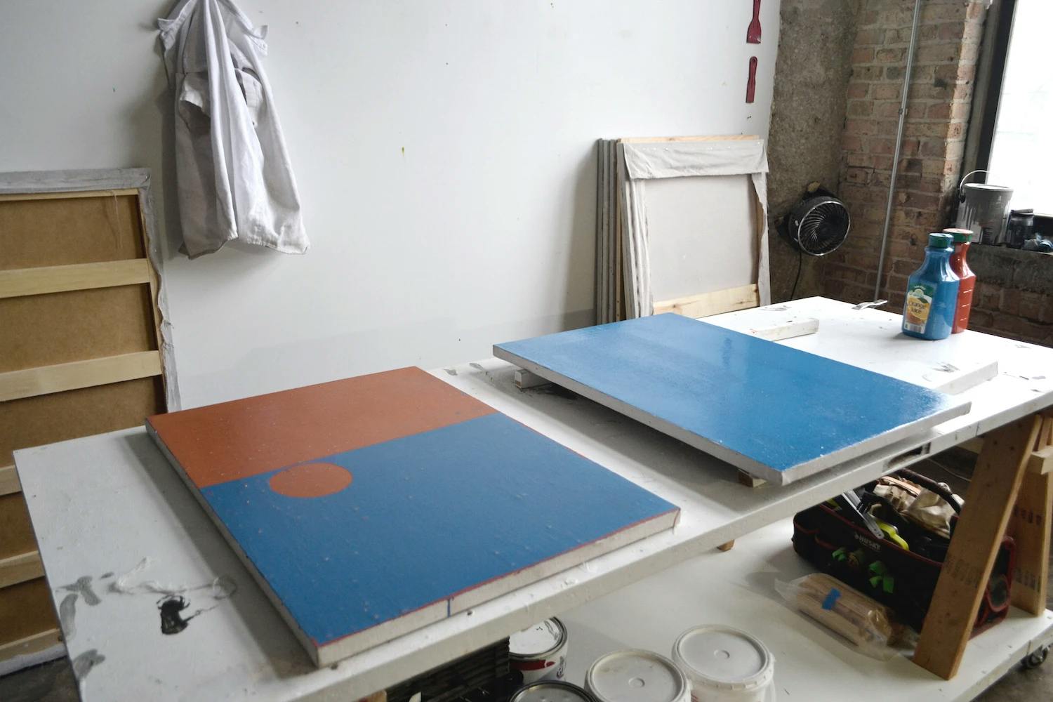 Minimalist, blue and red paintings on a table in artist Clay Mahn's studio.