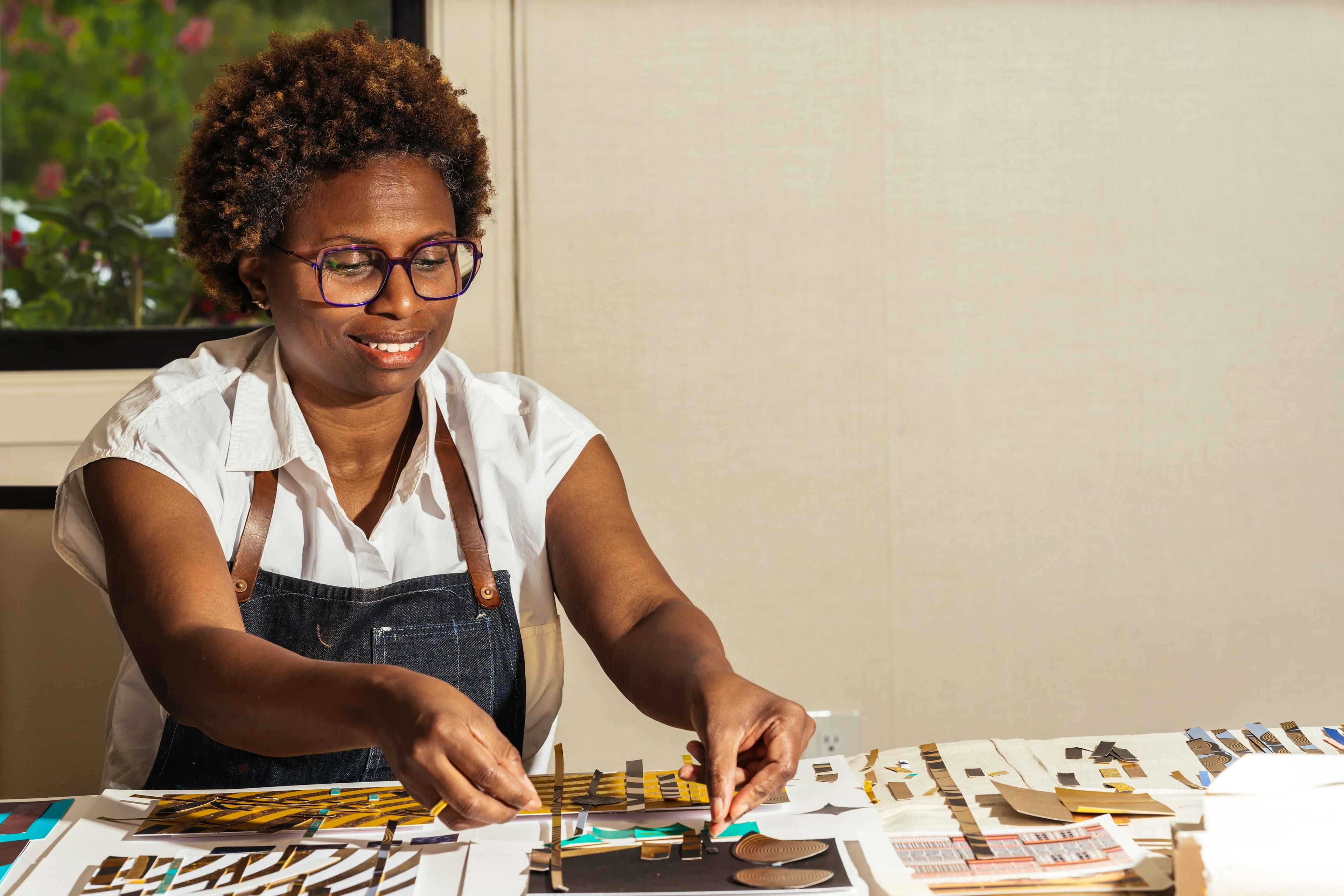 Artist Lisa Hunt working on a mixed media collage during her artist residency at MacArthur Place.