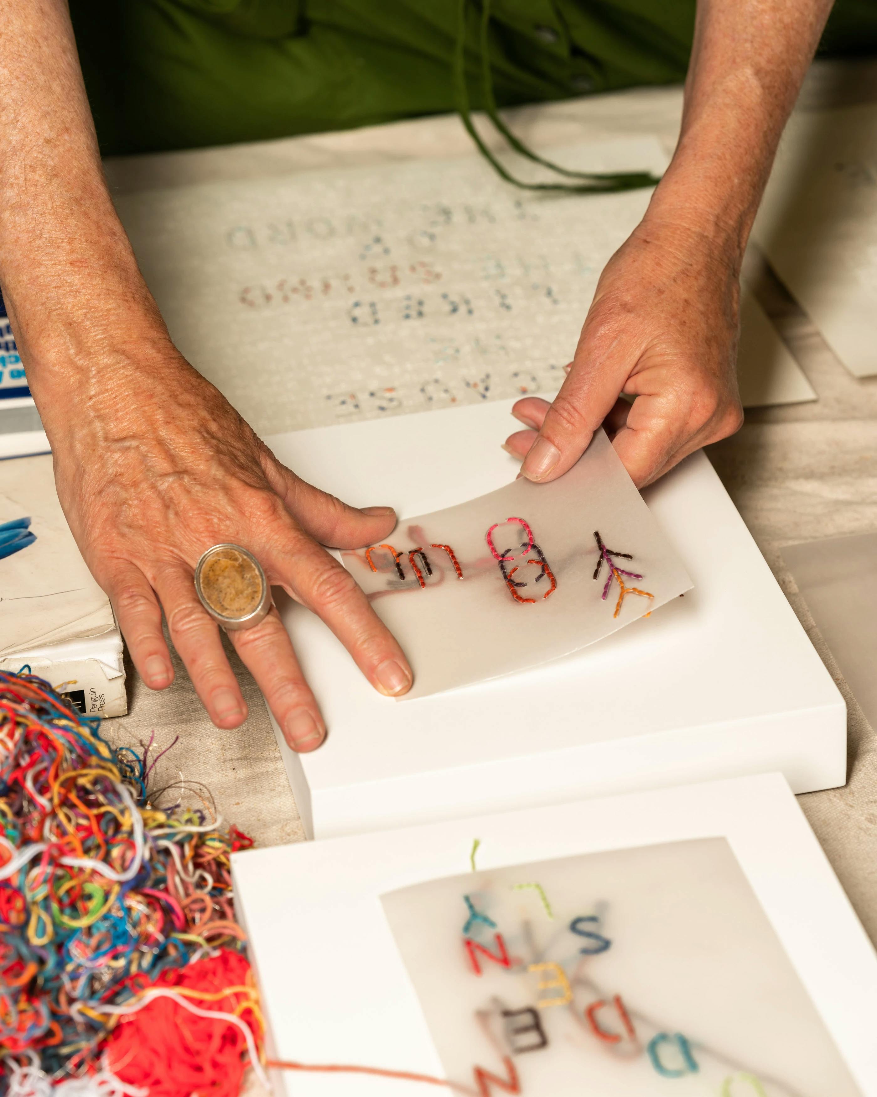 Artist Gail Tarantino placing threaded words on film onto canvas during her residency at MacArthur Place in Sonoma, CA. 