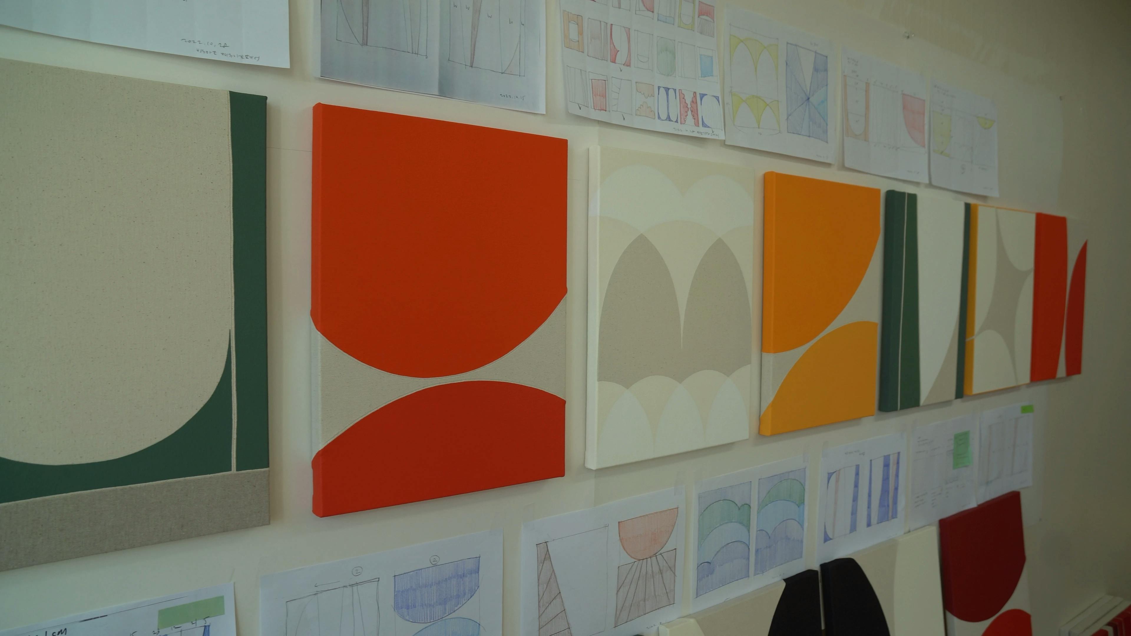 A row of paintings on canvas in Artist Hyun Jung Ahn's studio. 
