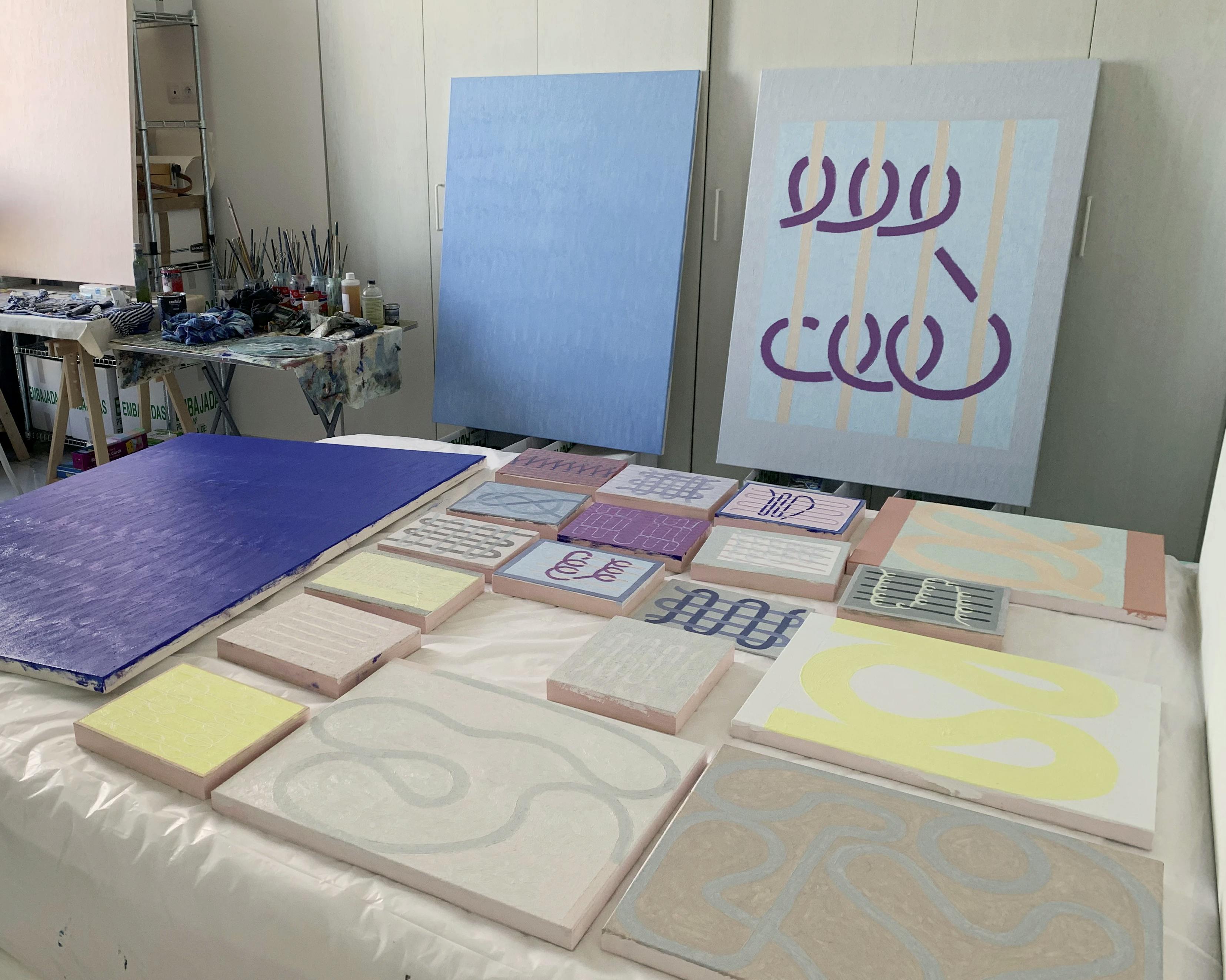 Paintings by Aschely Vaughan Cone on a table in her studio.