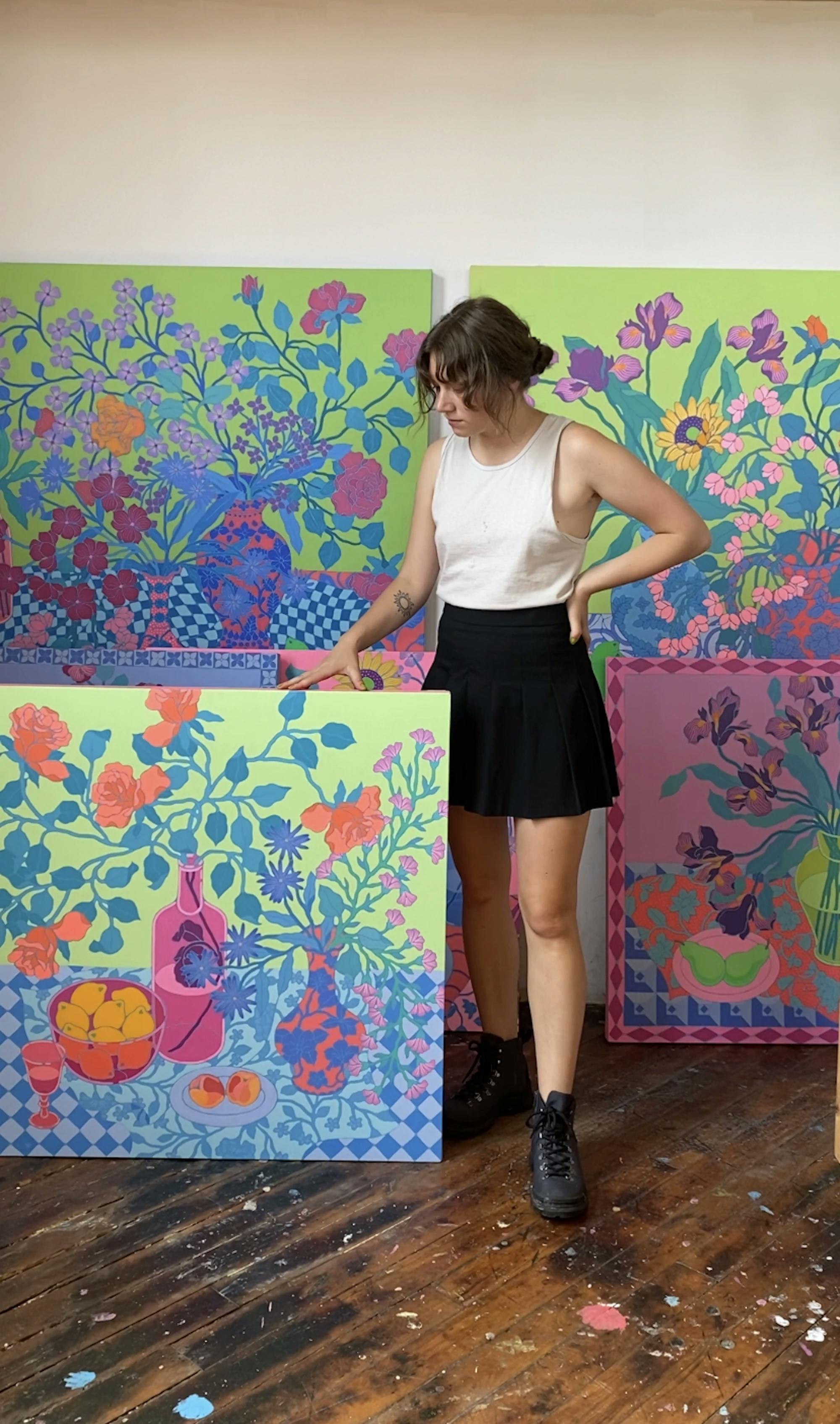 Artist Sarah Ingraham standing next to a large floral painting. 