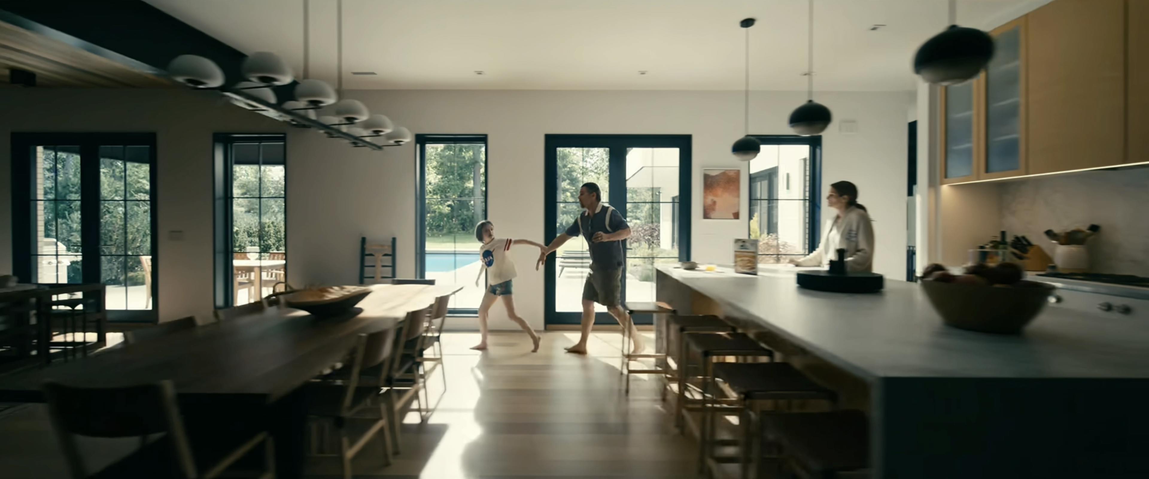 A red painting by artist Misato Suzuki in a film still of a modern kitchen from the Netflix movie, Leave the World Behind, featuring actors Julia Roberts and Ethan Hawke.